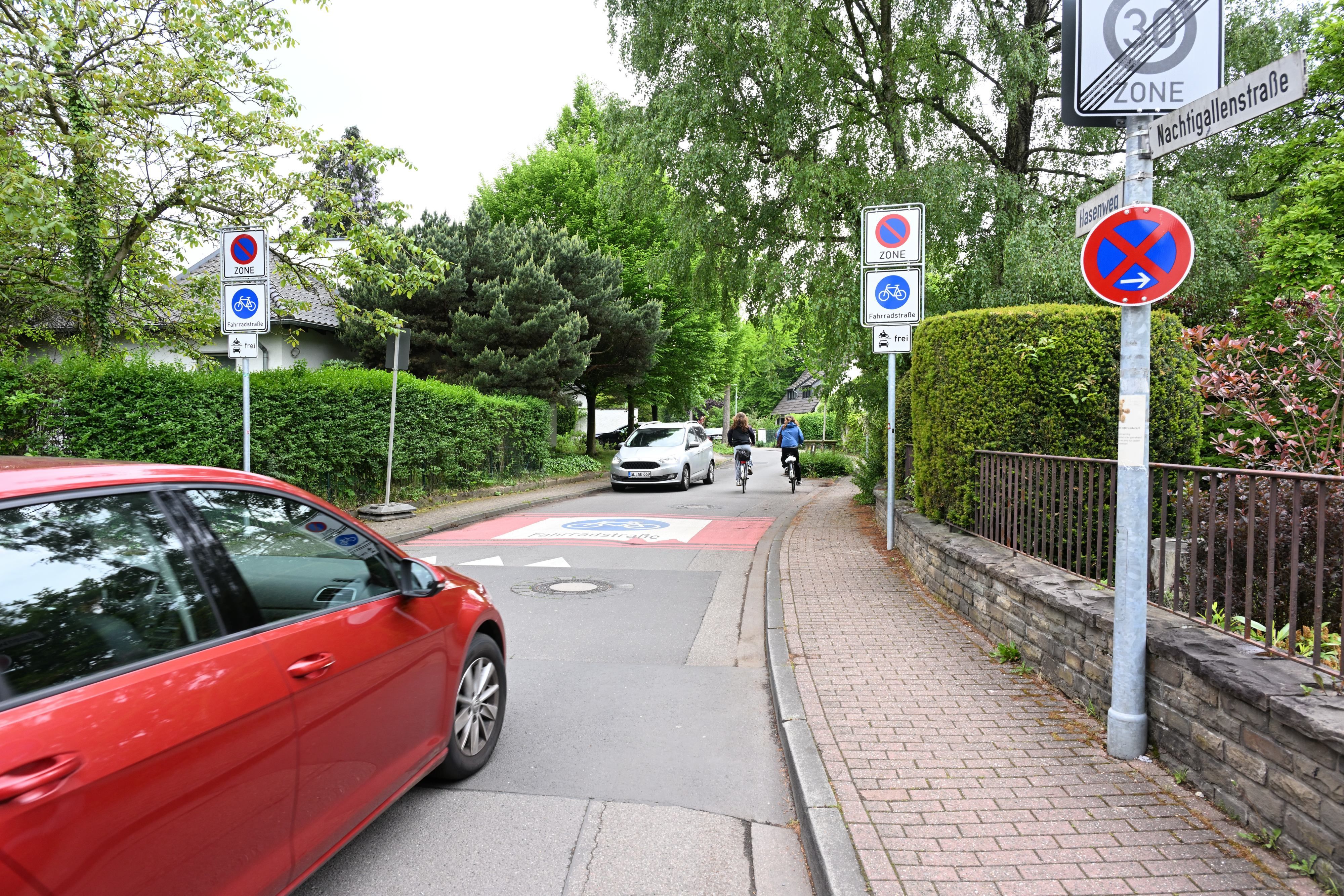 Rechts und links der Straße stehen Verkehrsschilder.
