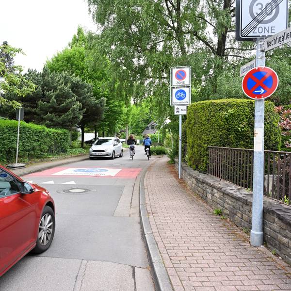 Rechts und links der Straße stehen Verkehrsschilder.