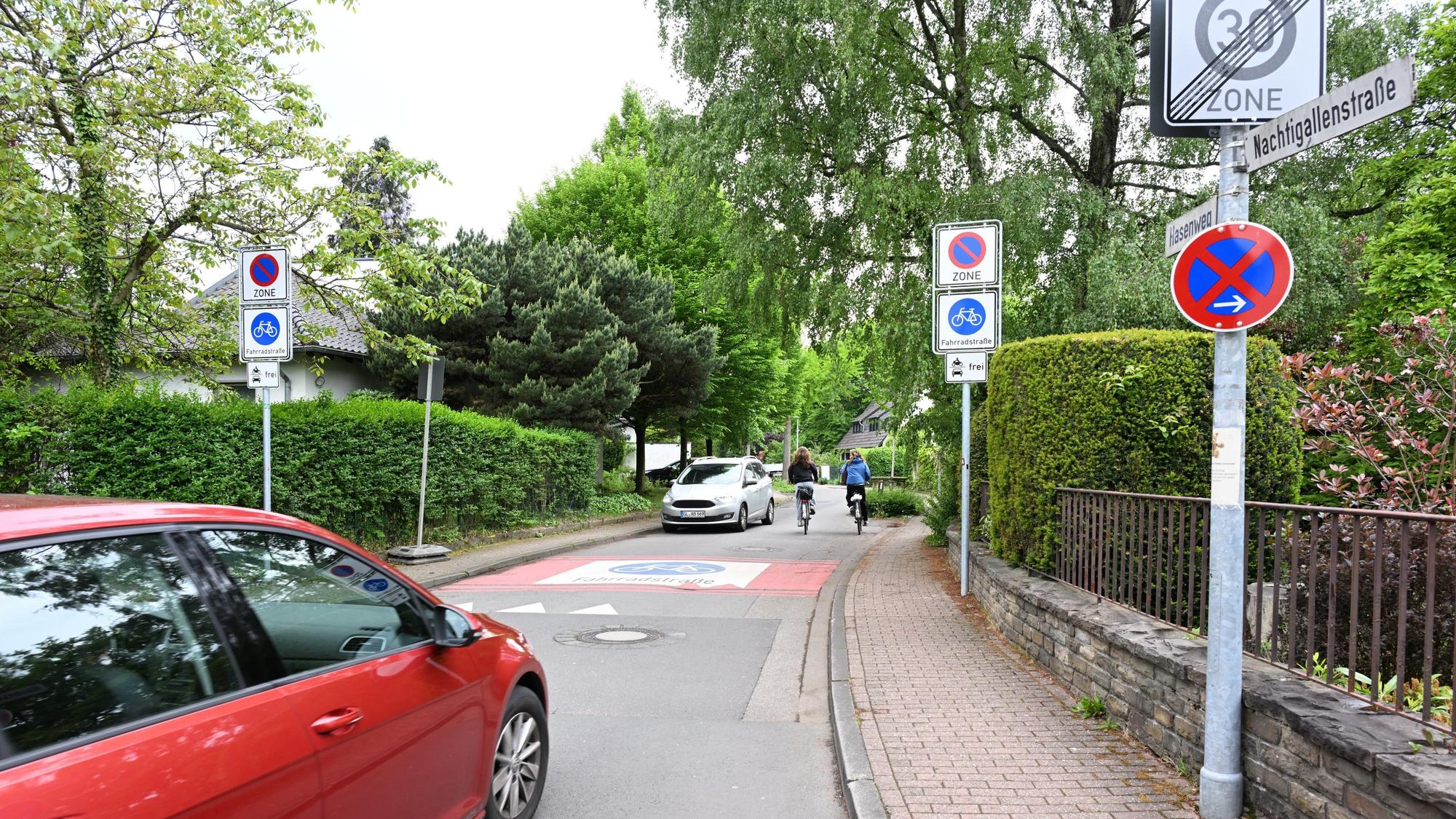 Rechts und links der Straße stehen Verkehrsschilder.