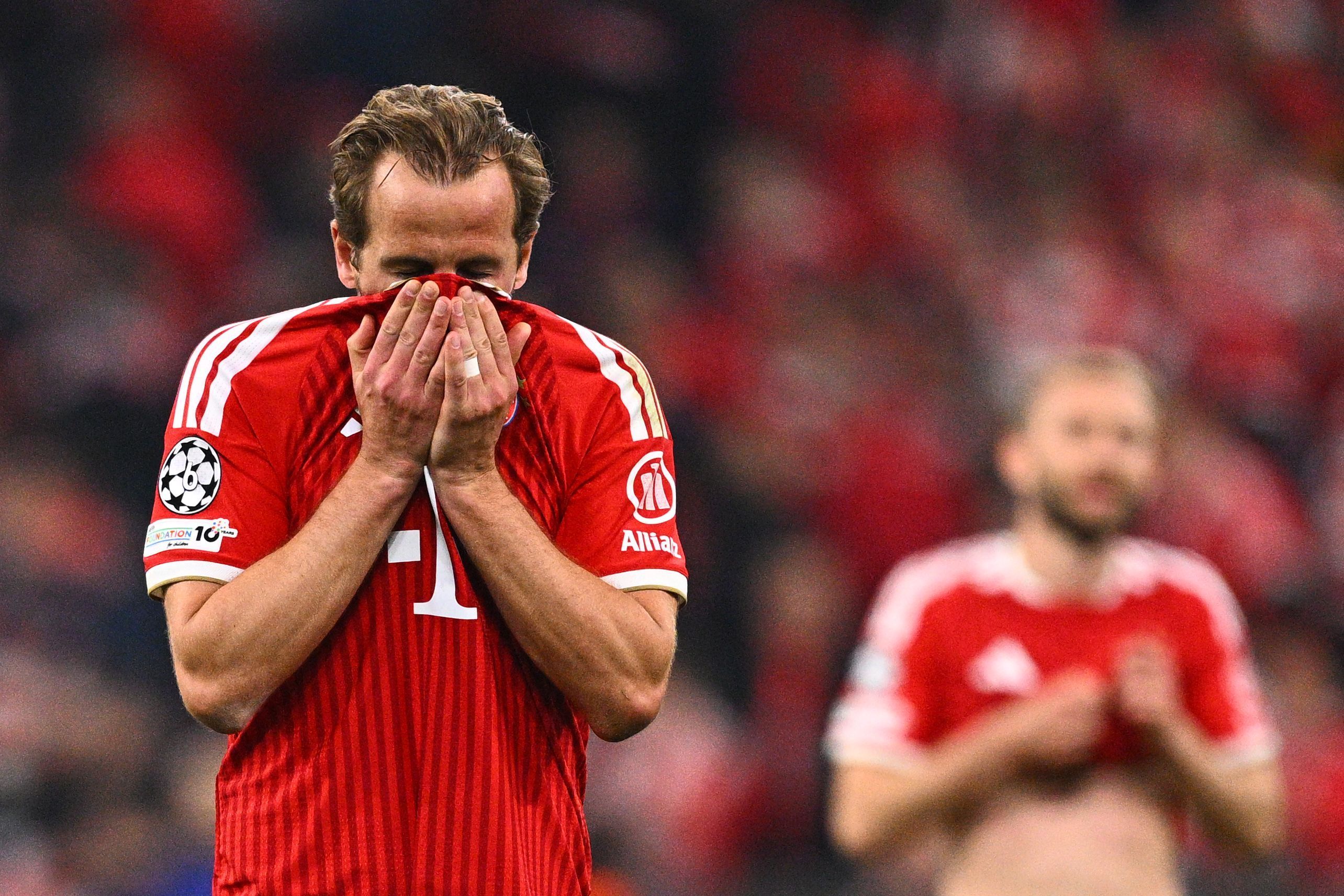 Harry Kane hält sich das Trikot vors Gesicht.