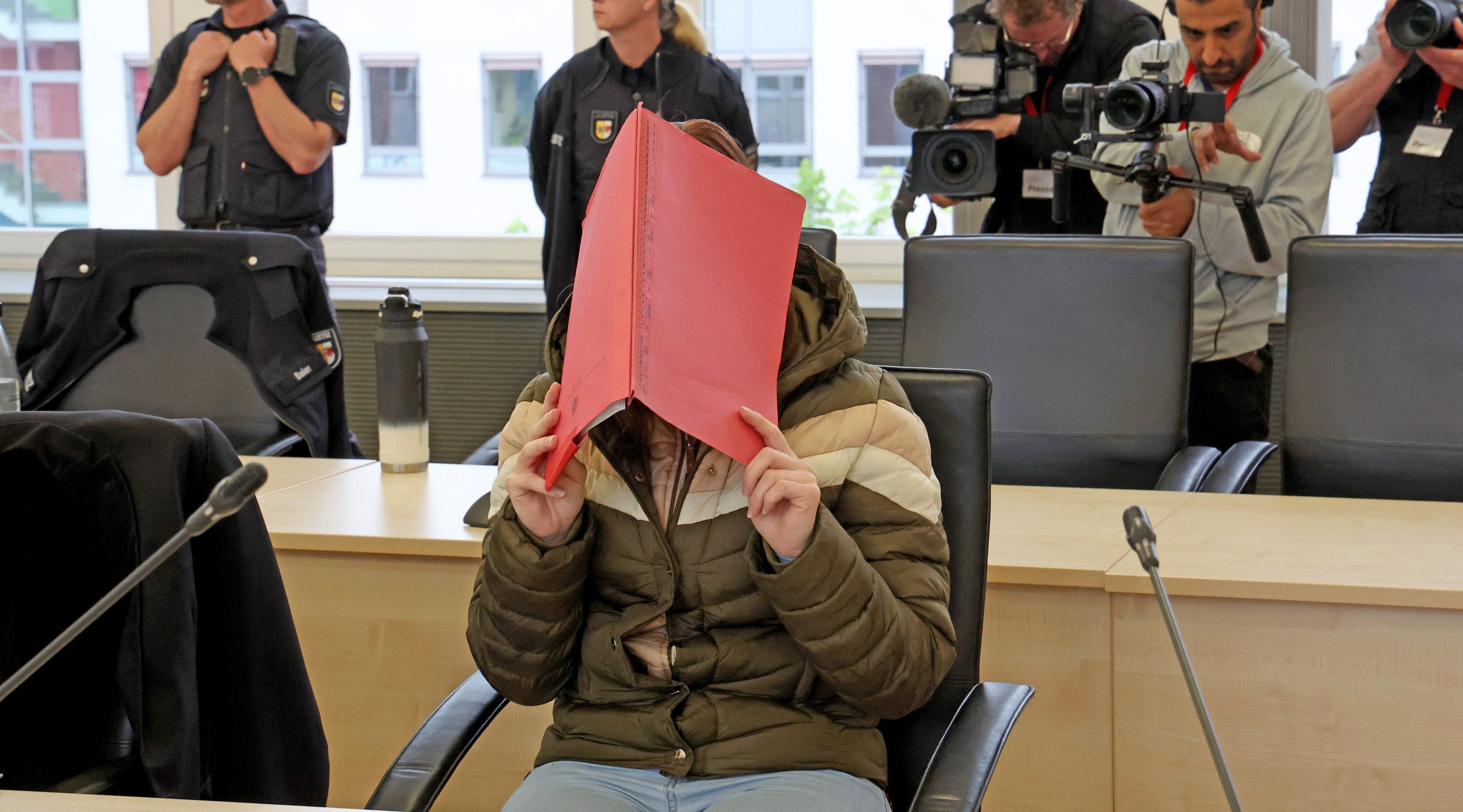 Die Angeklagte im Fall Fabian verdeckt ihr Gesicht im Gerichtssaal in Rostock.