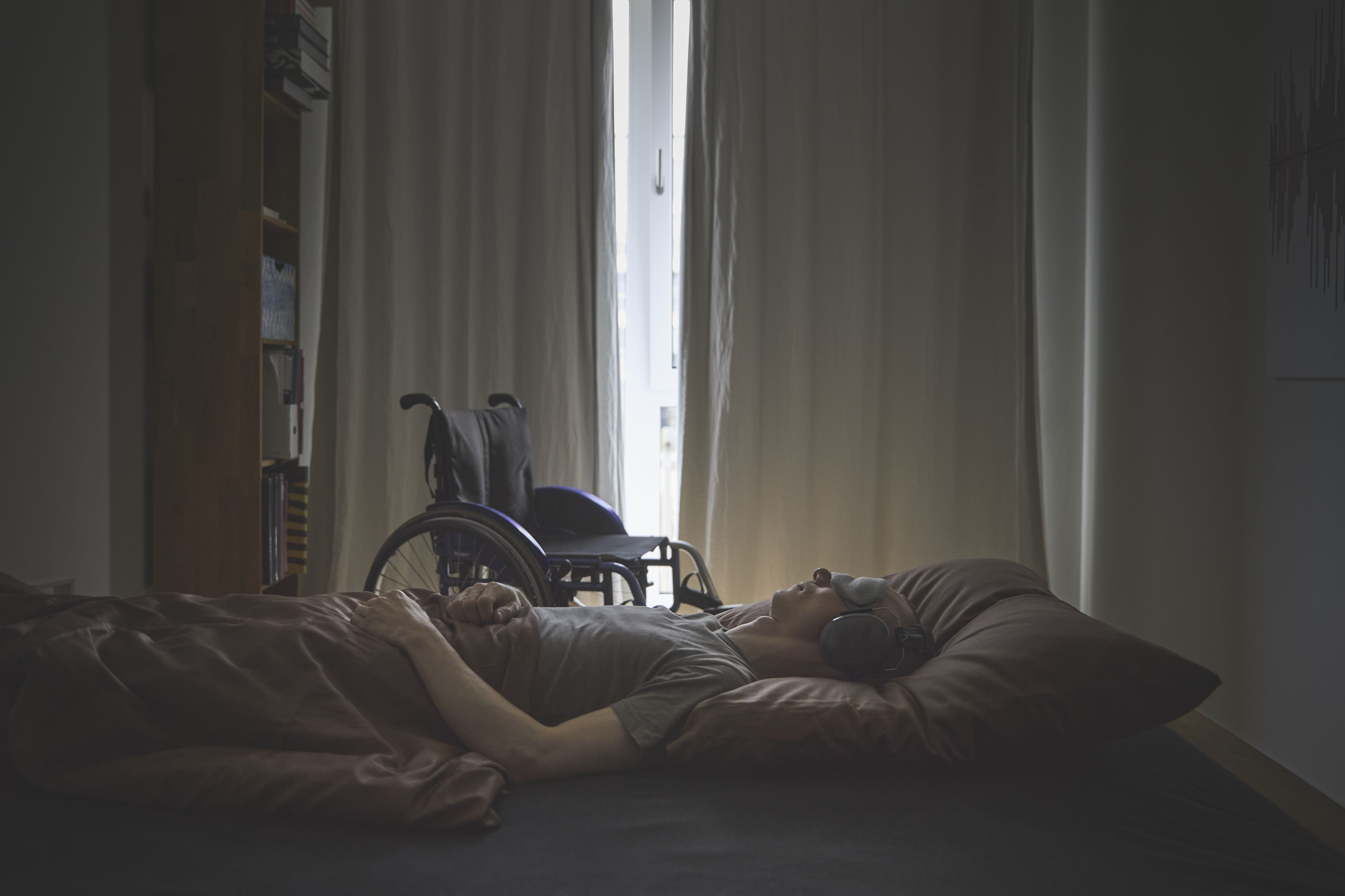 Ein Mensch mit ME/CFS liegt auf einem Bett.