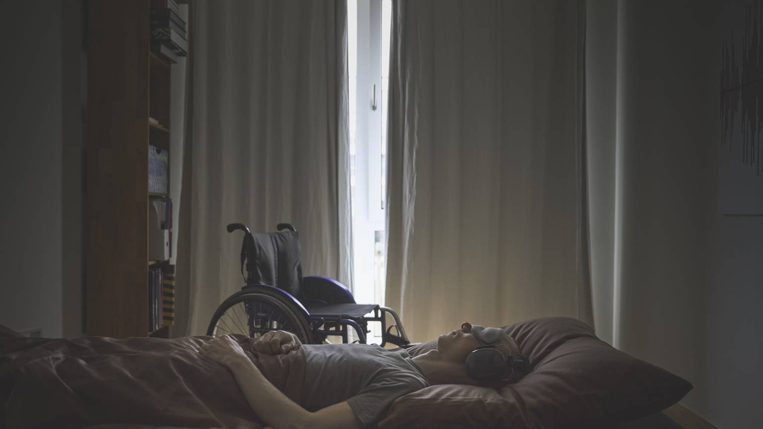 Ein Mensch mit ME/CFS liegt auf einem Bett.