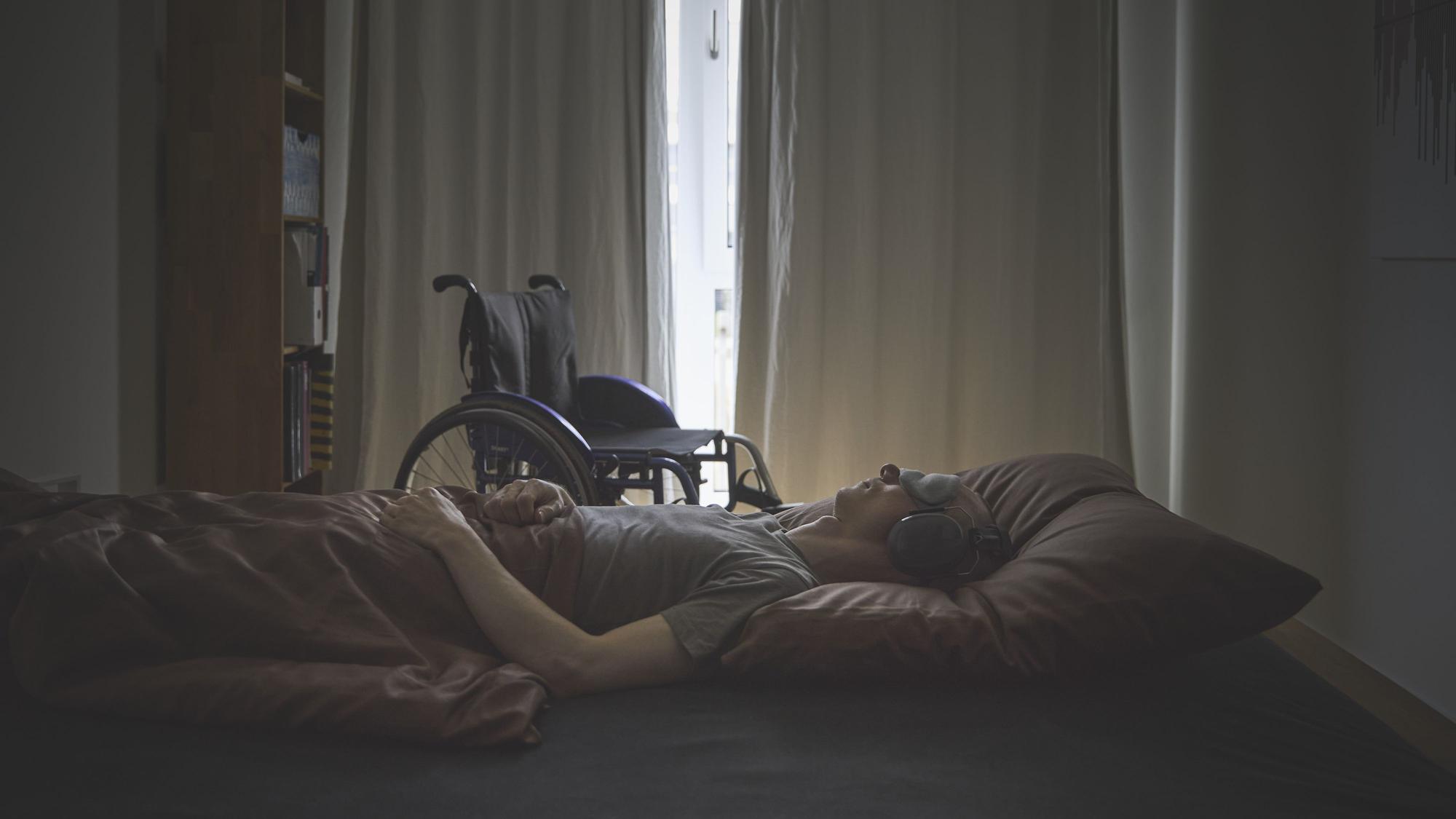 Ein Mensch mit ME/CFS liegt auf einem Bett.