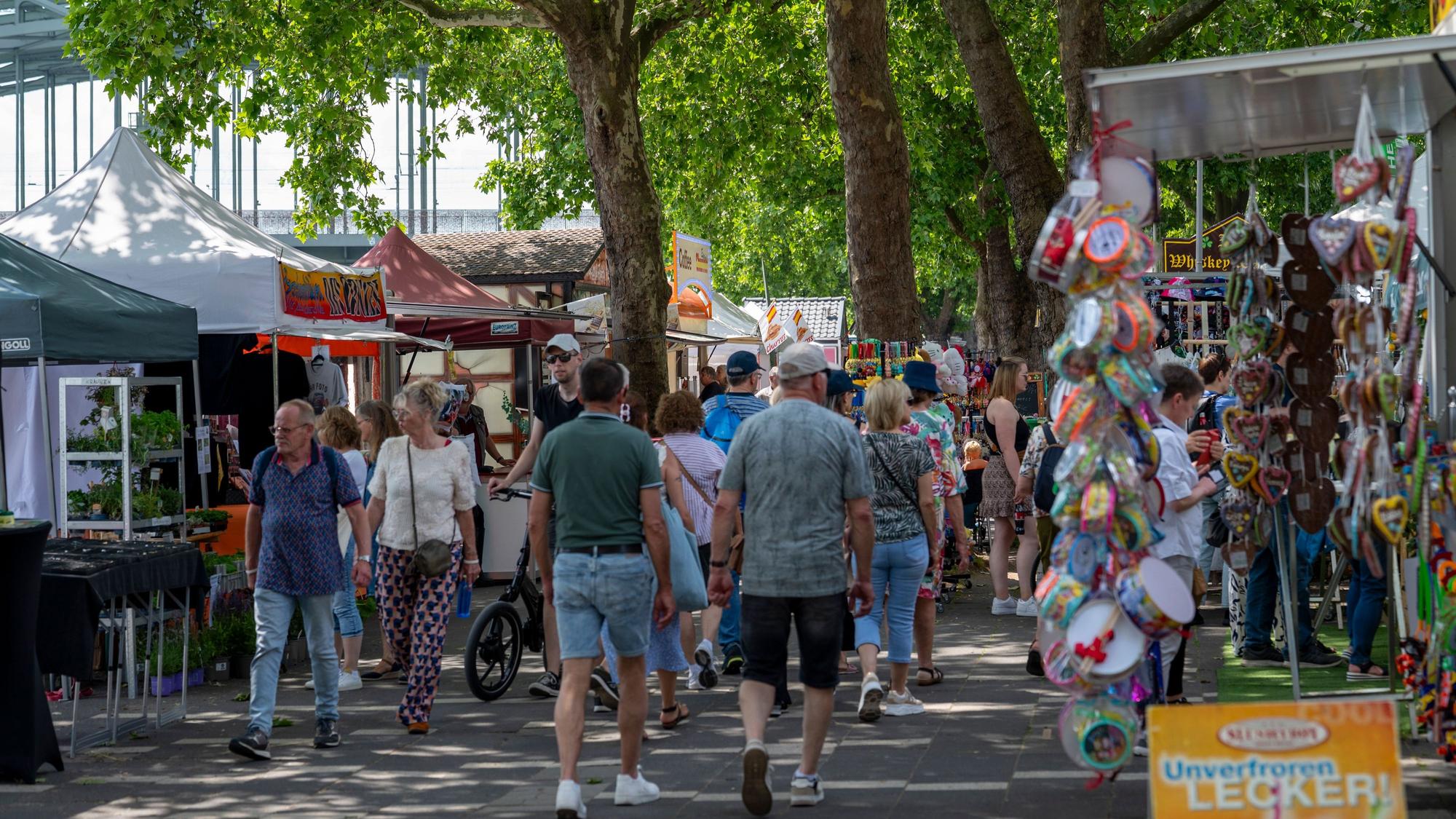 „Frühlingsfest auf der Rheinuferpromenade“ mit vielen Ständen und Besuchern.