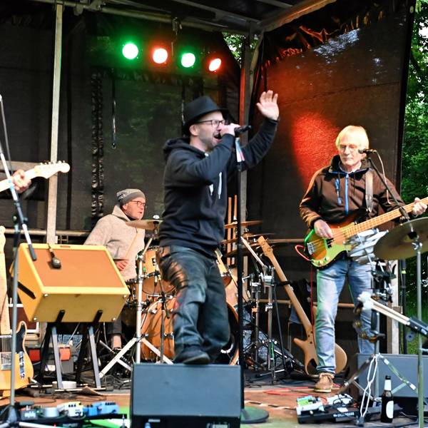 Drei Musiker stehen auf der Bühne.