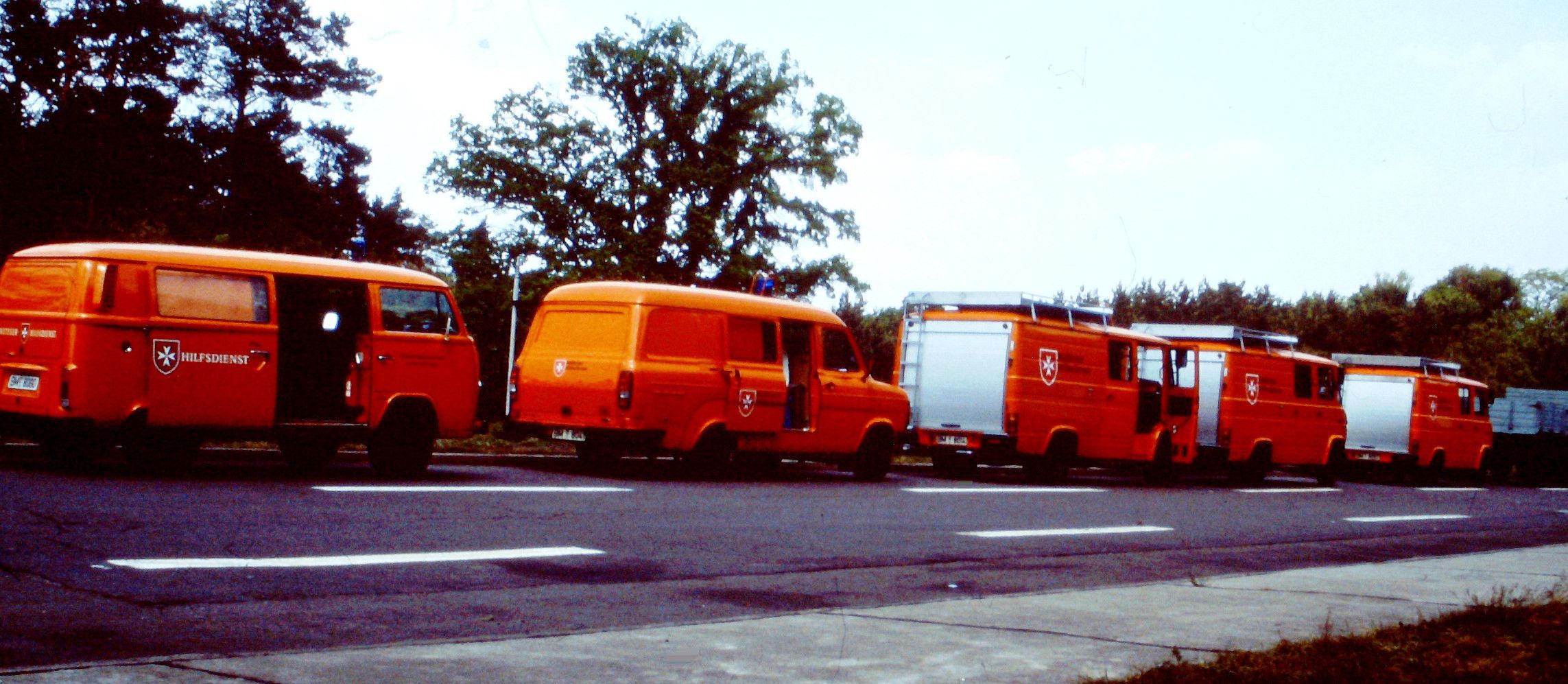 Das Bild zeigt fünf rote Einsatzwagen, die hintereinander geparkt sind.