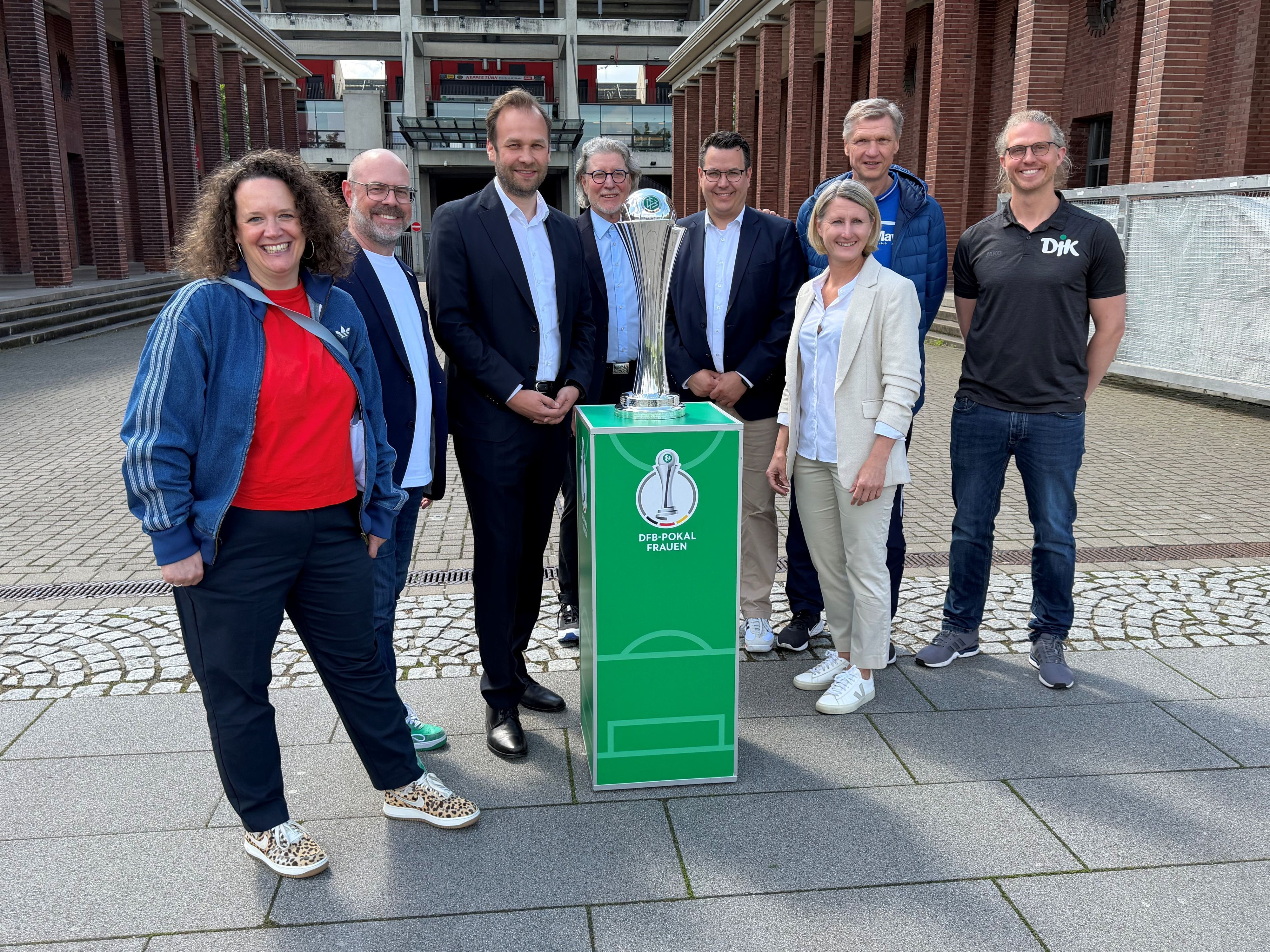 Die Beteiligten am diesjährigen DFB-Pokalfinale der Frauen freuen sich auf das Rahmenprogramm vor dem großen Endspiel. Lucie Benz, Lutz Wingerath, Robert Voigtsberger, Toni Schumacher, Rudi Rheinstädtler, Sonja Fuss, Torsten May und Nicolas Niermann (v.l.) bei der Programmpräsentation am Donnerstag (7. Mai 2026).