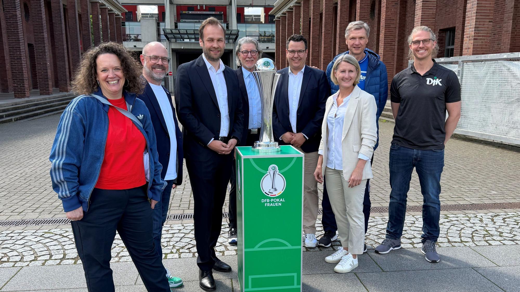 Die Beteiligten am diesjährigen DFB-Pokalfinale der Frauen freuen sich auf das Rahmenprogramm vor dem großen Endspiel. Lucie Benz, Lutz Wingerath, Robert Voigtsberger, Toni Schumacher, Rudi Rheinstädtler, Sonja Fuss, Torsten May und Nicolas Niermann (v.l.) bei der Programmpräsentation am Donnerstag (7. Mai 2026).