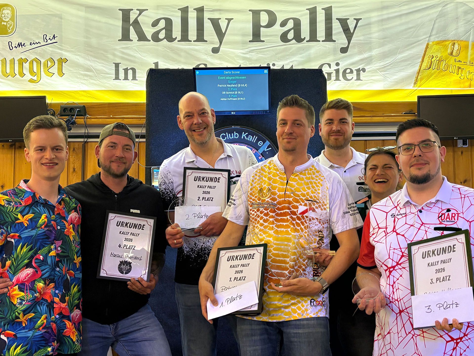 Das Gruppenbild zeigt mehrere Männer und eine Frau, einige halten Urkunden und Glaspokale in den Händen.