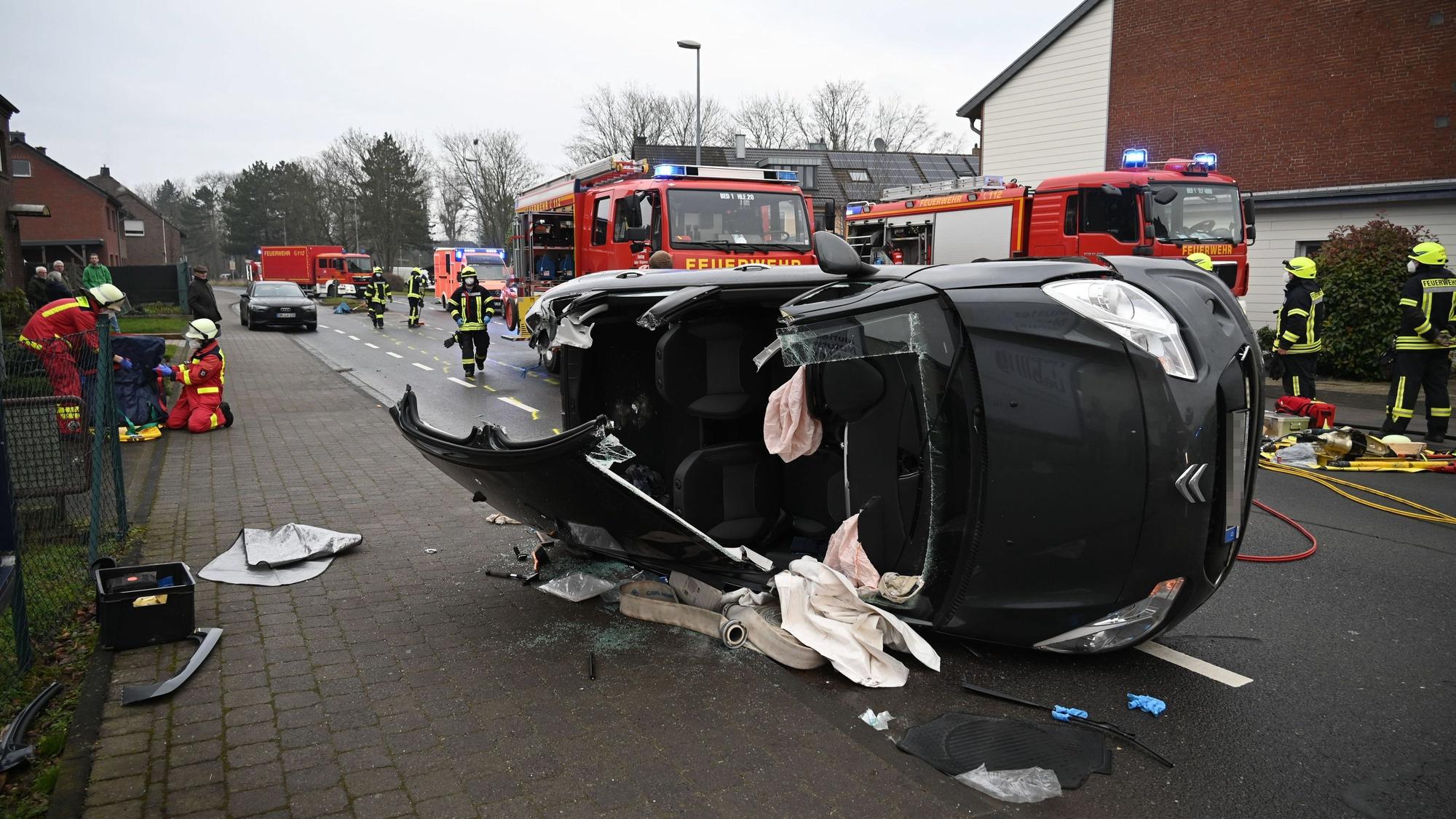 Zu sehen ist ein auf der Seite liegendes Auto, dessen Dach von der Feuerwehr aufgeschnitten wurde.