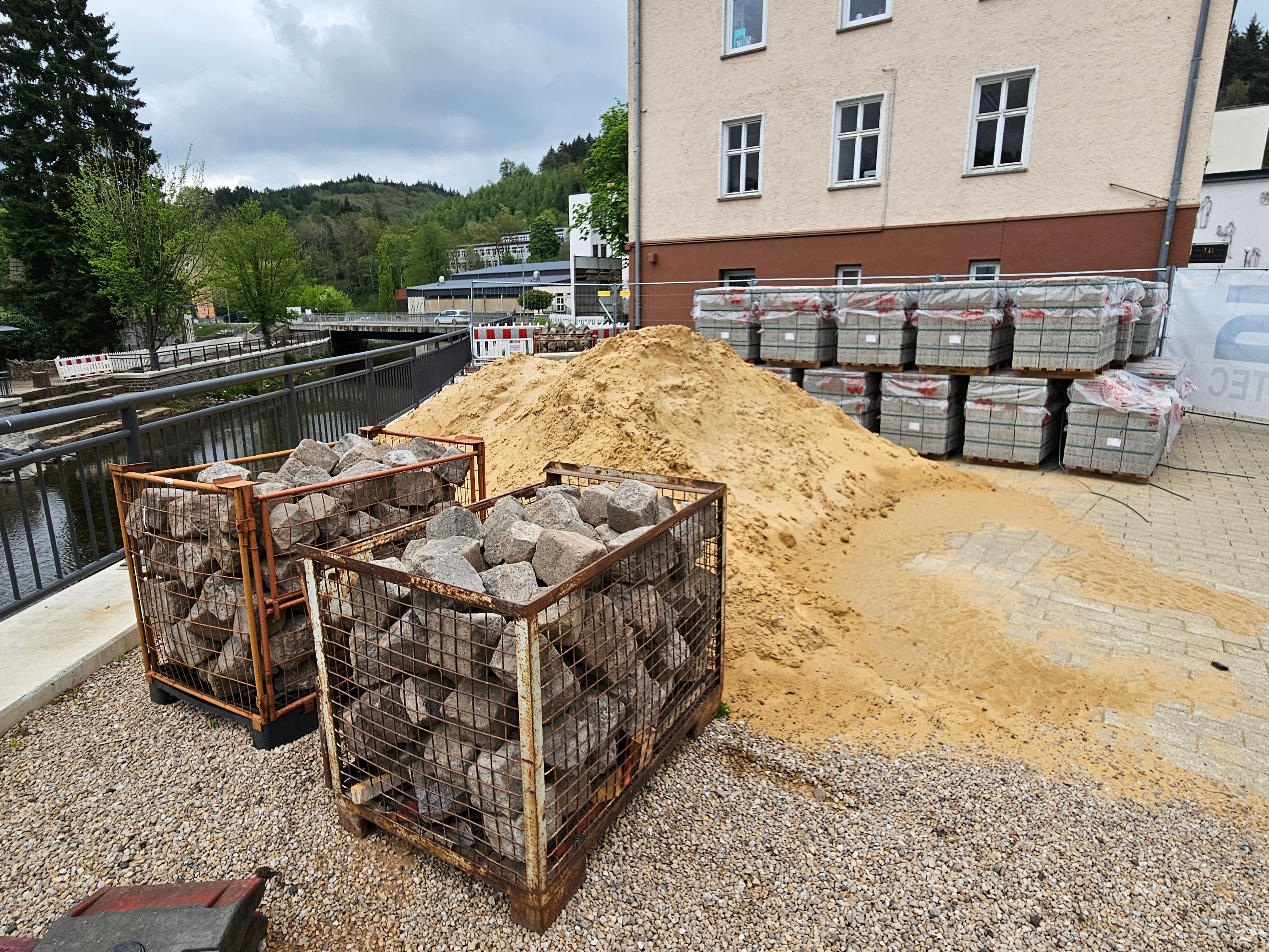 Neben dem alten Rathaus liegen Sand und Steine.