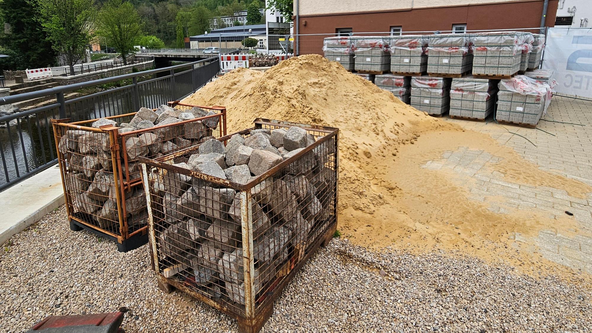 Neben dem alten Rathaus liegen Sand und Steine.