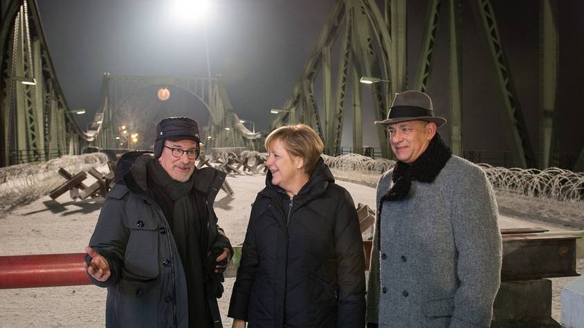 Ende 2014 drehte Starregisseur Steven Spielberg (links) mit Hollywoodstar Tom Hanks an und auf der Glienicker Brücke Szenen für den Historienfilm „Bridge of Spies“. Einen Besuch am Set ließ sich die damalige Kanzlerin Angela Merkel nicht entgehen. (Bild: Guido Bergmann/Bundesregierung via Getty Images)
