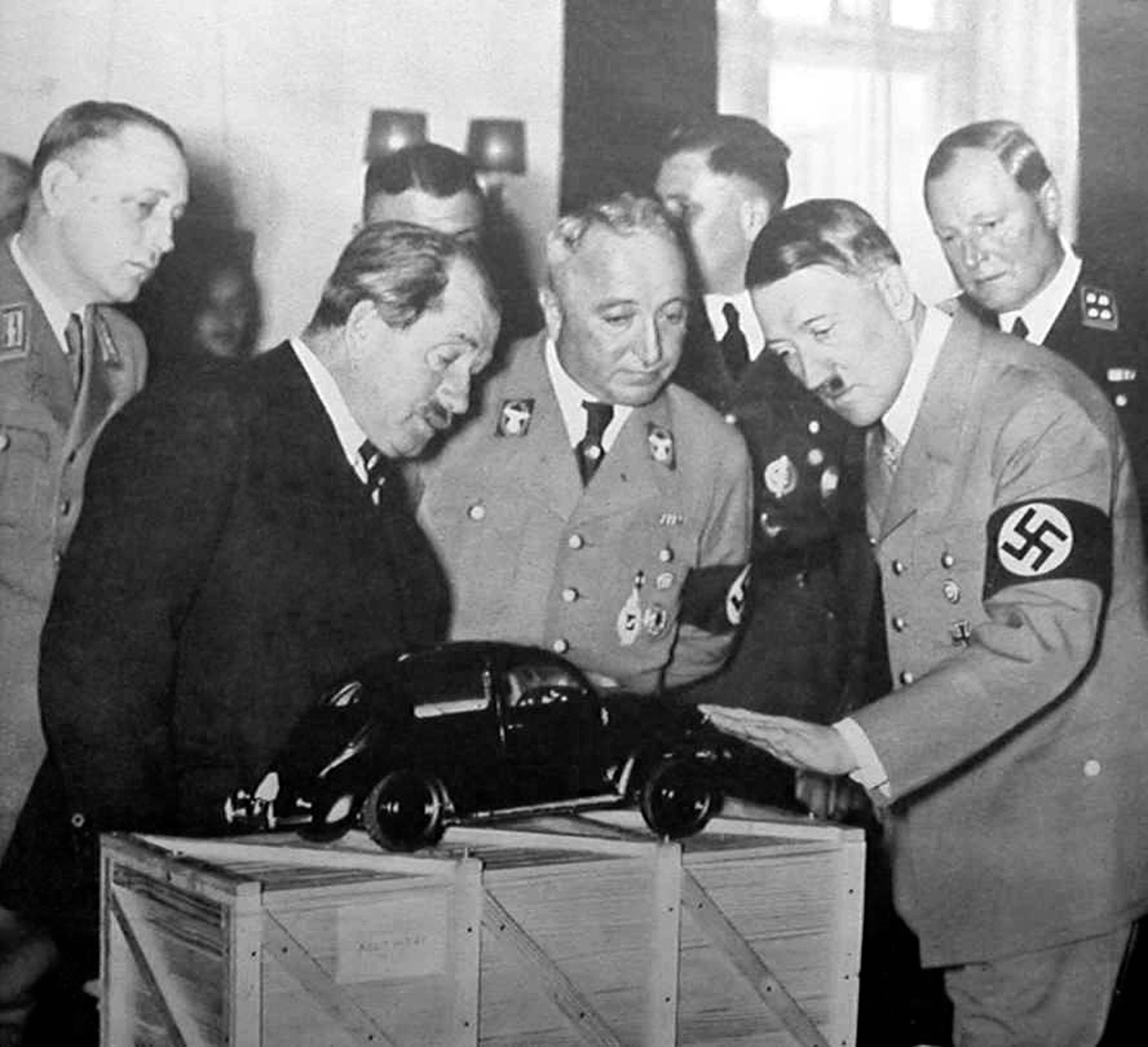 20. April 1939: Der Kölner NS-Verbrecher Robert Ley (vorne Mitte) neben seinem Förderer Adolf Hitler. Ferdinand Porsche (links, im dunklen Anzug) zeigt dem Führer ein neu gestaltetes Volkswagen-Cabriolet.