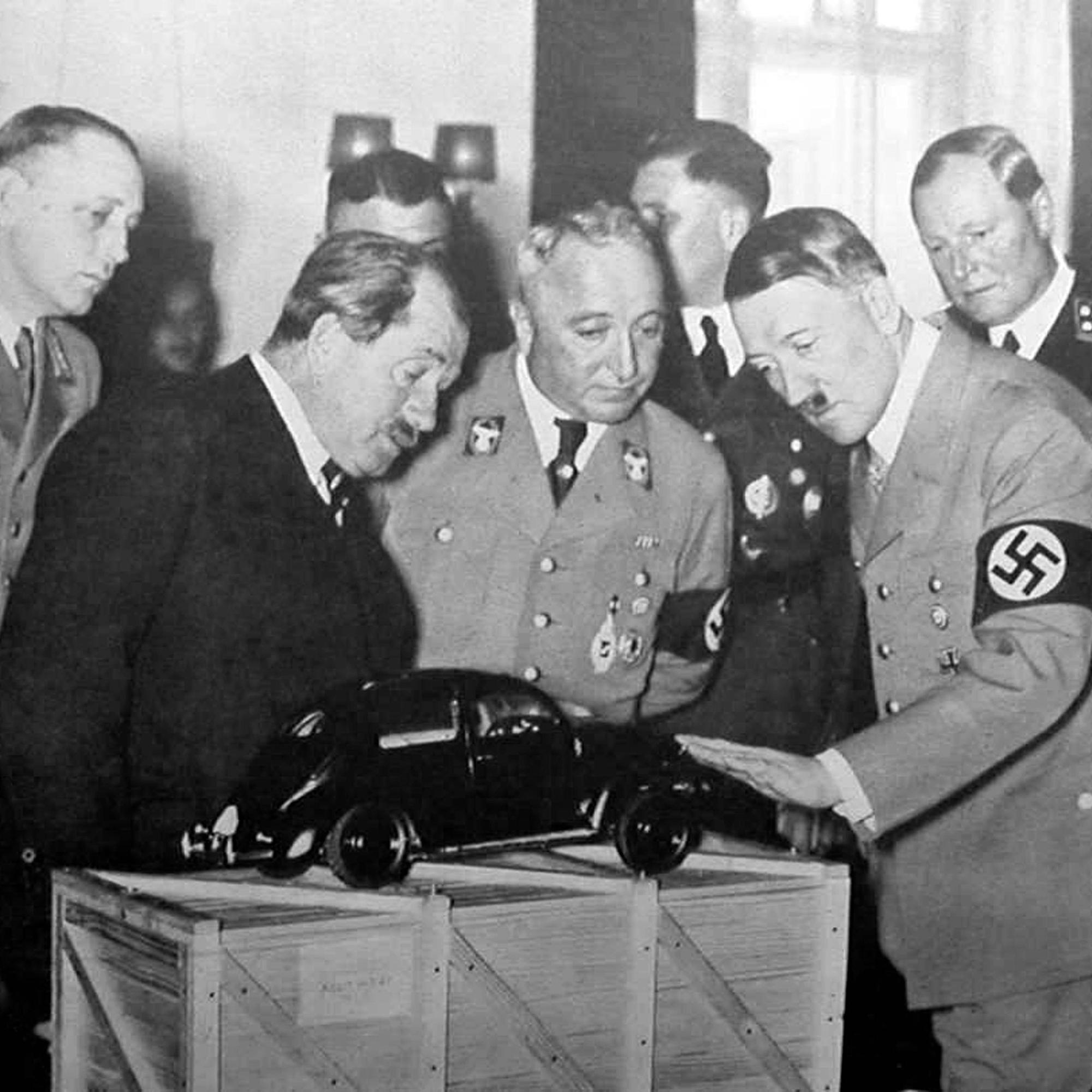 20. April 1939: Der Kölner NS-Verbrecher Robert Ley (vorne Mitte) neben seinem Förderer Adolf Hitler. Ferdinand Porsche (links, im dunklen Anzug) zeigt dem Führer ein neu gestaltetes Volkswagen-Cabriolet.