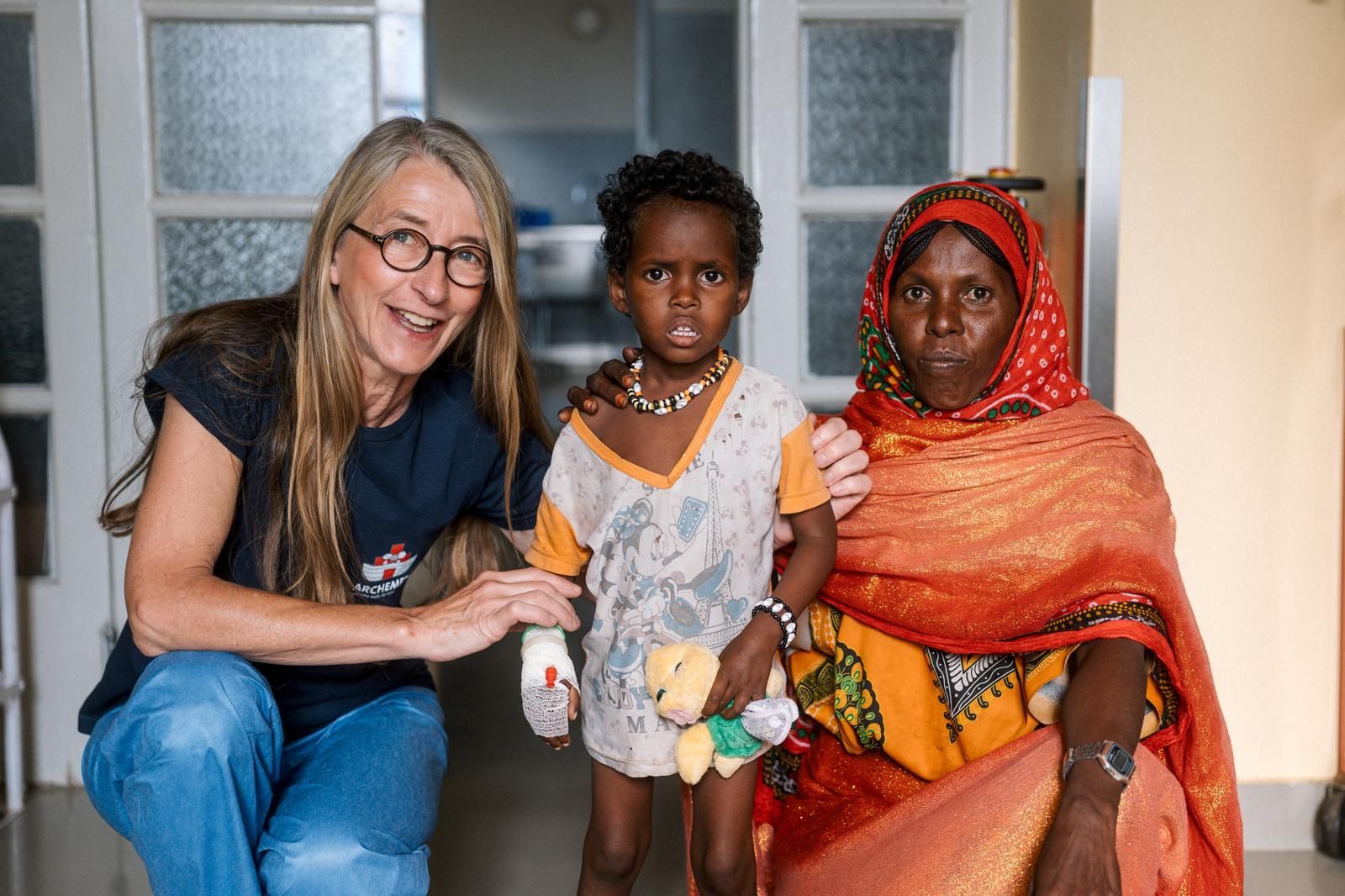 Professorin Martina Messing-Jünger in Eritrea mit einem von ihr operierten Kind und seiner Mutter.
