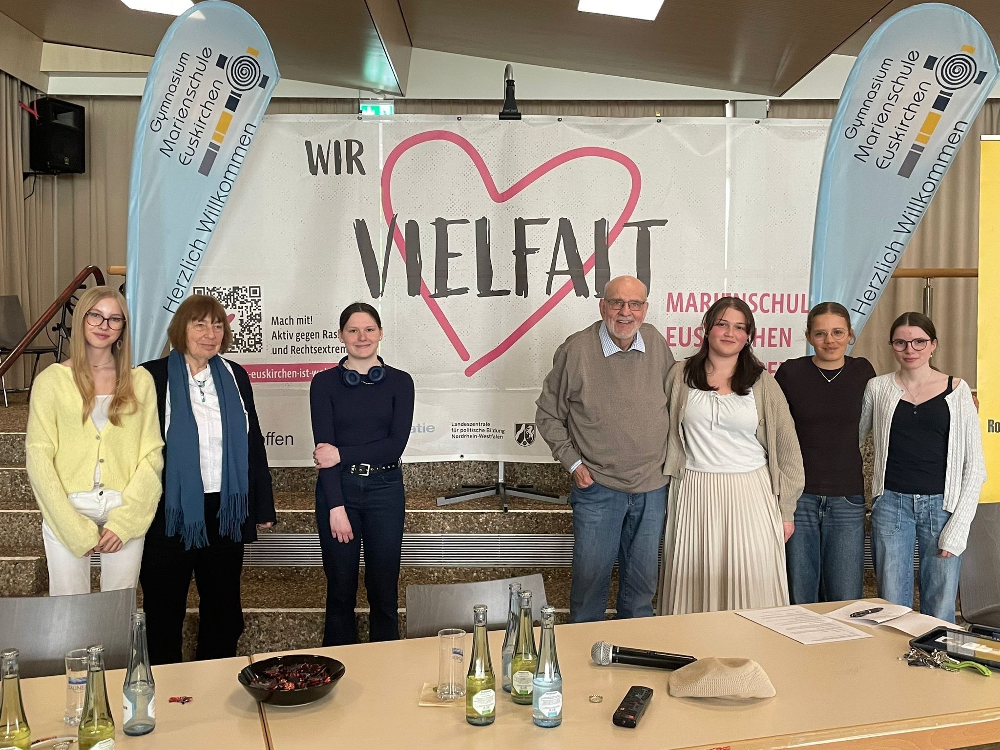 Barbara Brix (2.v.l.) und Bernhard Esser stehen mit Schülerinnen der Marienschule vor einem Transparent mit der Aufschrift „Vielfalt“.