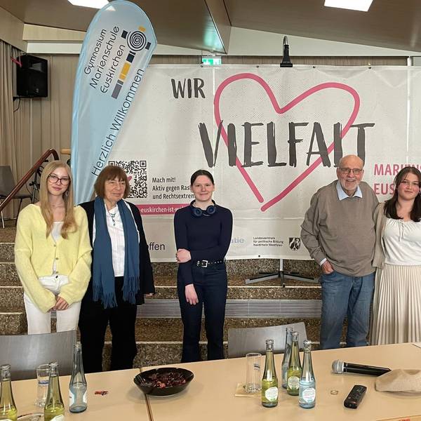 Barbara Brix (2.v.l.) und Bernhard Esser stehen mit Schülerinnen der Marienschule vor einem Transparent mit der Aufschrift „Vielfalt“.