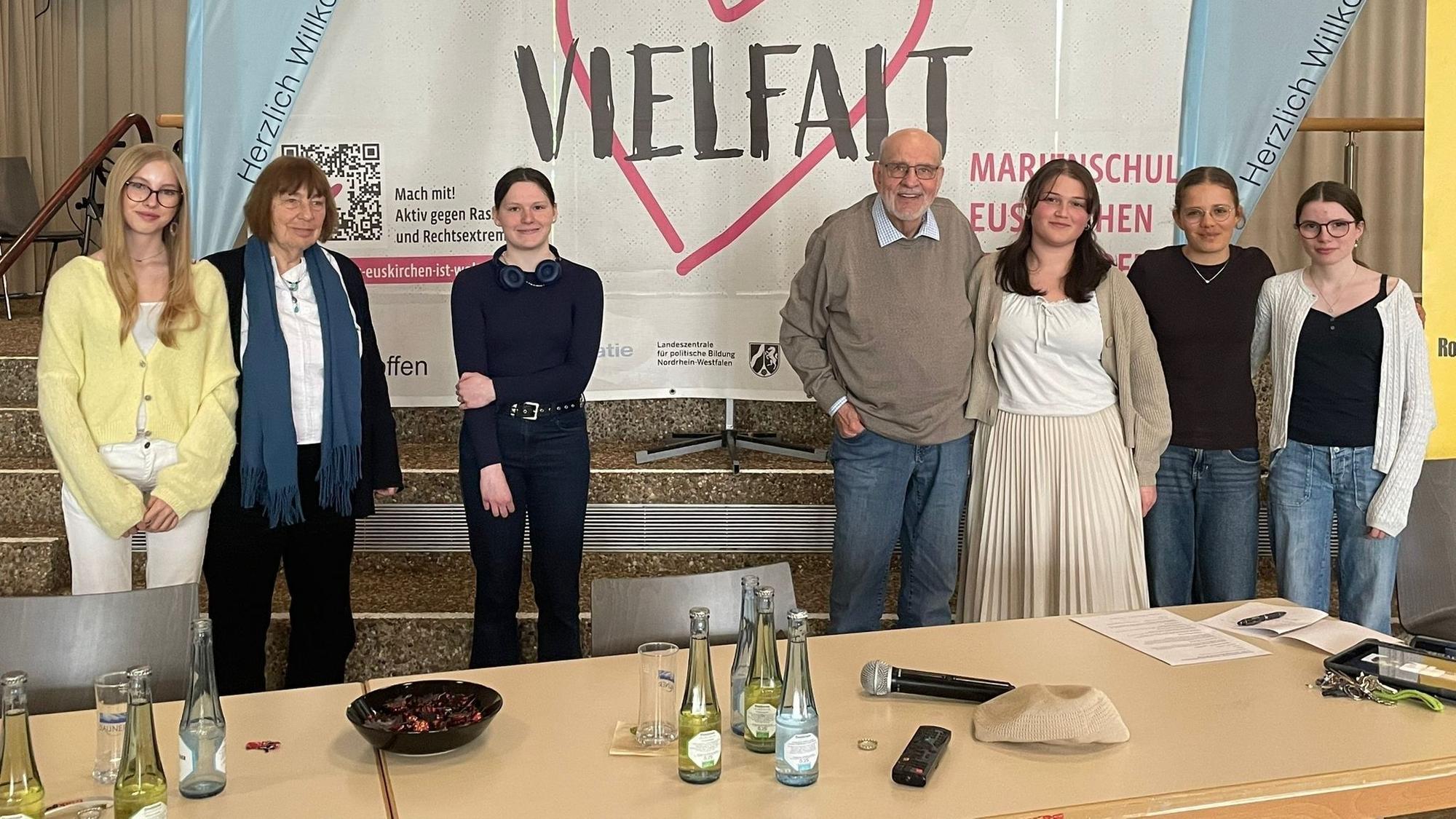 Barbara Brix (2.v.l.) und Bernhard Esser stehen mit Schülerinnen der Marienschule vor einem Transparent mit der Aufschrift „Vielfalt“.