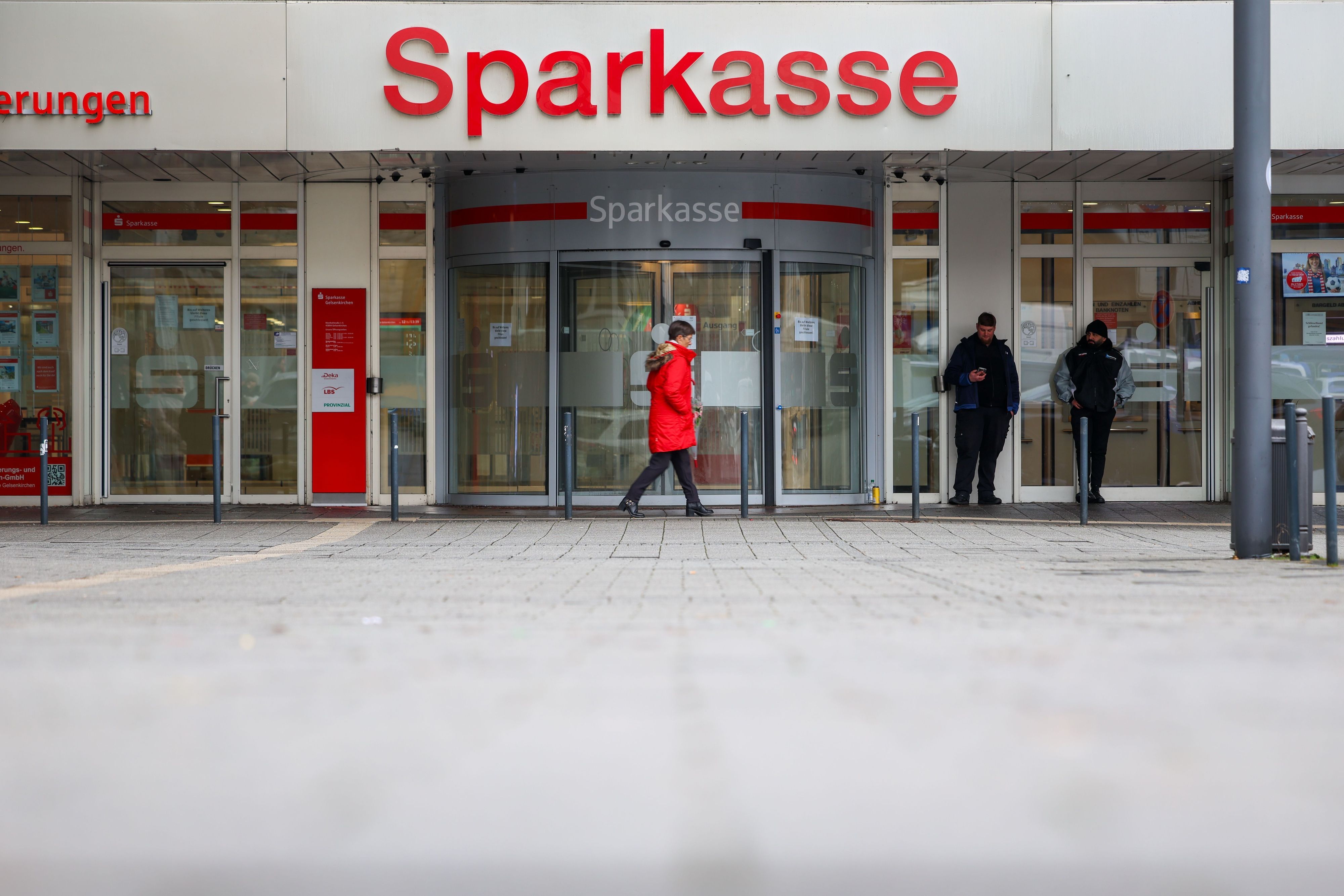 Security-Mitarbeiter stehen vor der Sparkasse Gelsenkirchen, die auf dem Archivbild noch geschlossen ist.