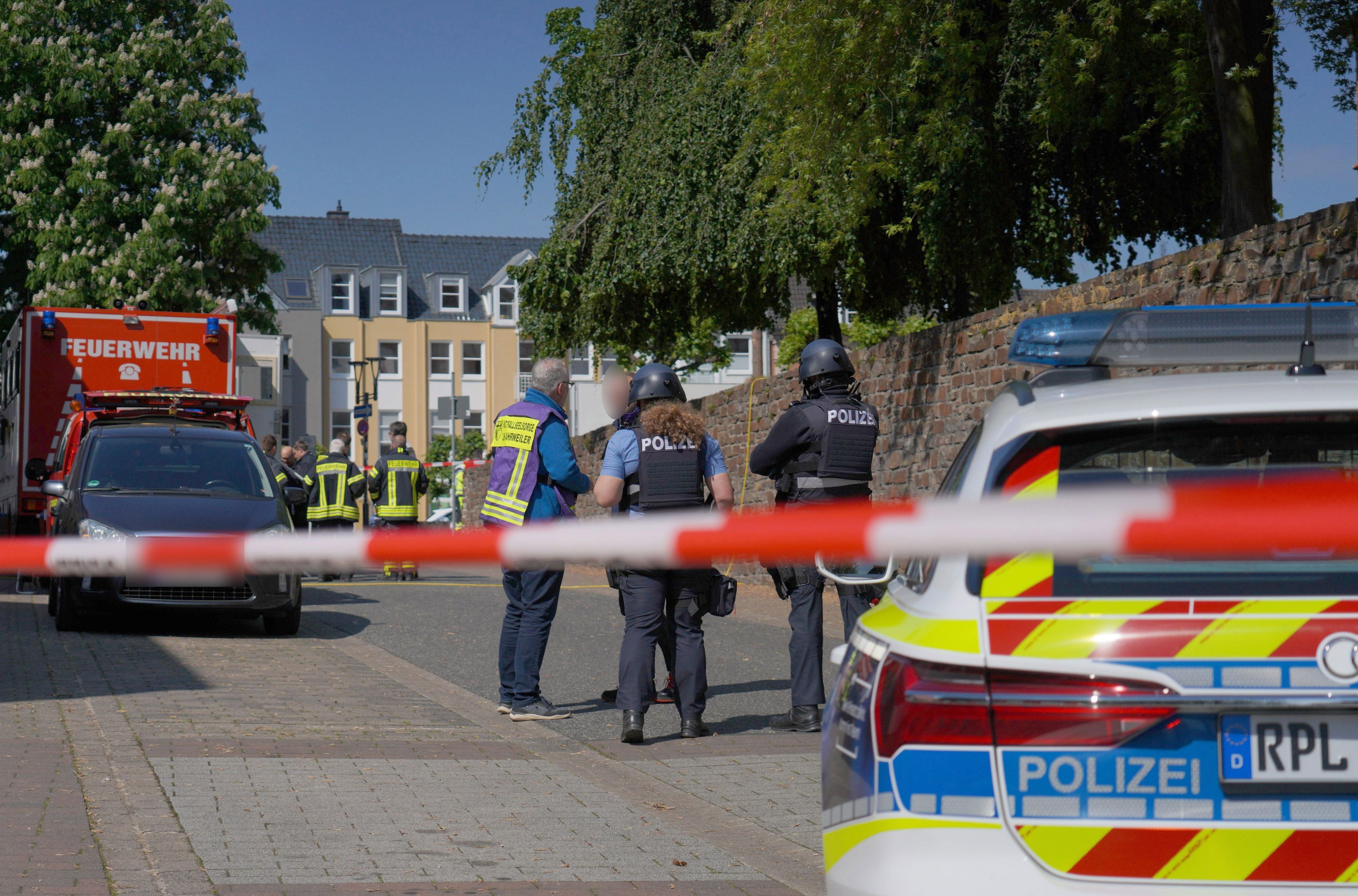 Polizisten und Polizeifahrzeuge stehen hinter Absperrband. In einer Bankfiliale im rheinland-pfälzischen Sinzig ist es nach ersten Erkenntnissen der Polizei zu einer Geiselnahme gekommen.