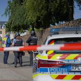 Polizisten und Polizeifahrzeuge stehen hinter Absperrband. In einer Bankfiliale im rheinland-pfälzischen Sinzig ist es nach ersten Erkenntnissen der Polizei zu einer Geiselnahme gekommen.