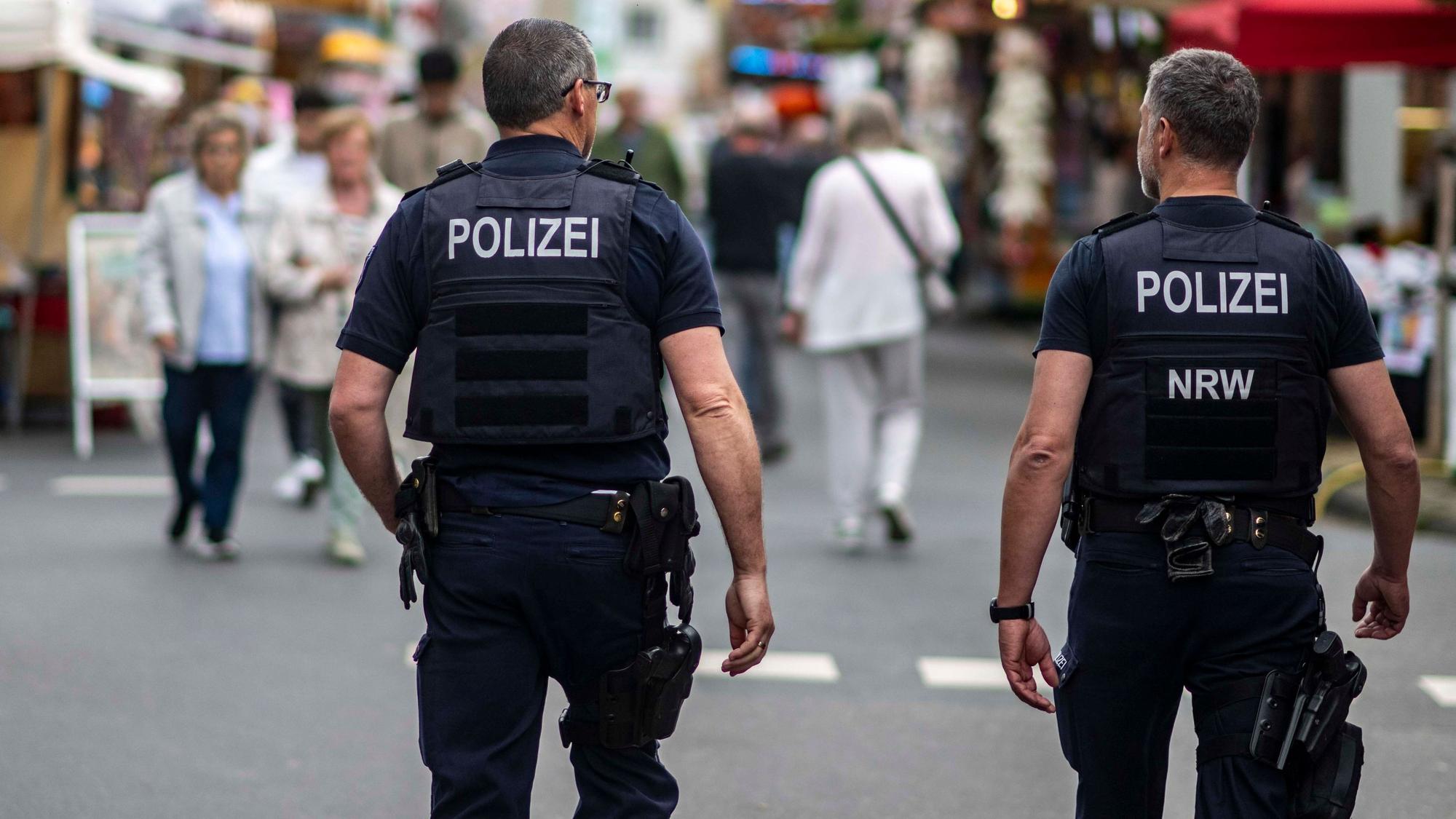 Das Bild zeigt zwei Polizisten, die über die Euskirchener Kirmes gehen.