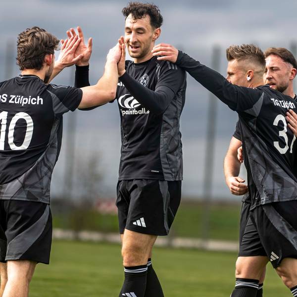 Das Bild zeigt vier Fußballer des TuS Zülpich, die sich über einen Treffer freuen.