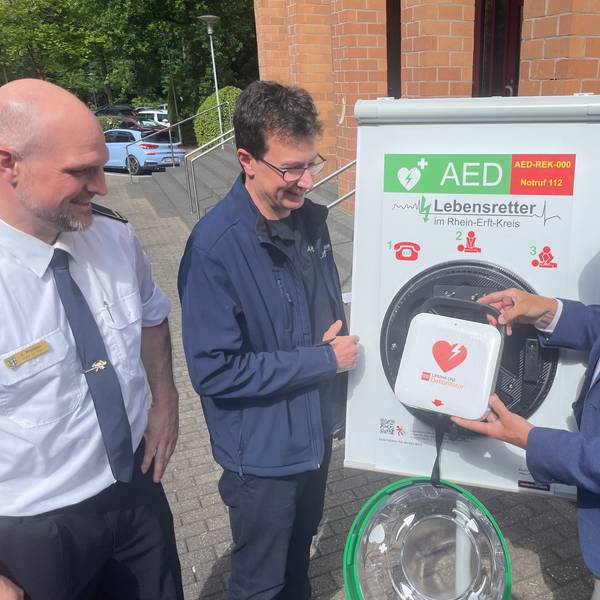 Das Foto zeigt die Vertreter des Kreises und des Vereins mit einem Defibrillator.