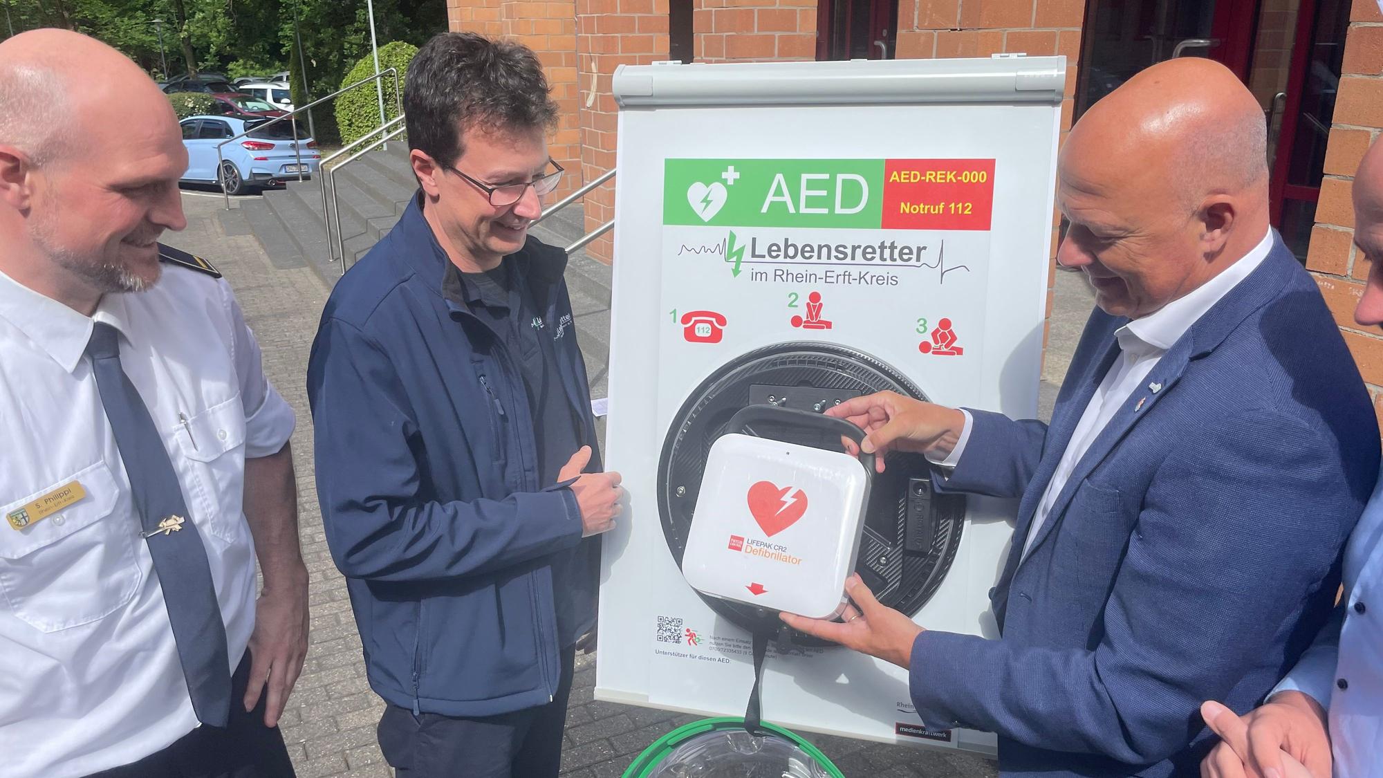 Das Foto zeigt die Vertreter des Kreises und des Vereins mit einem Defibrillator.