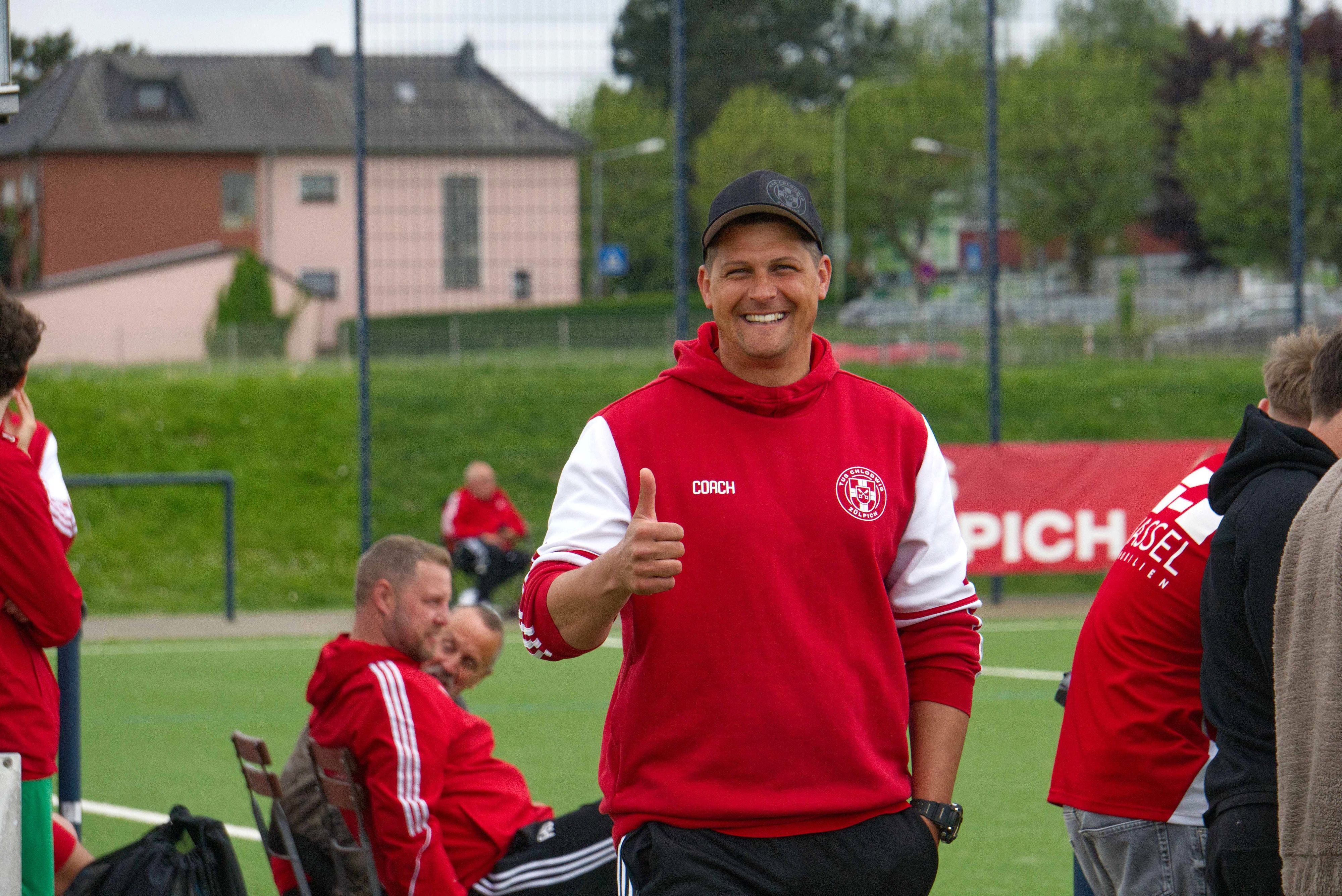 Das Bild zeigt den Trainer des TuS Zülpich, wie er in die Kamera lächelt.
