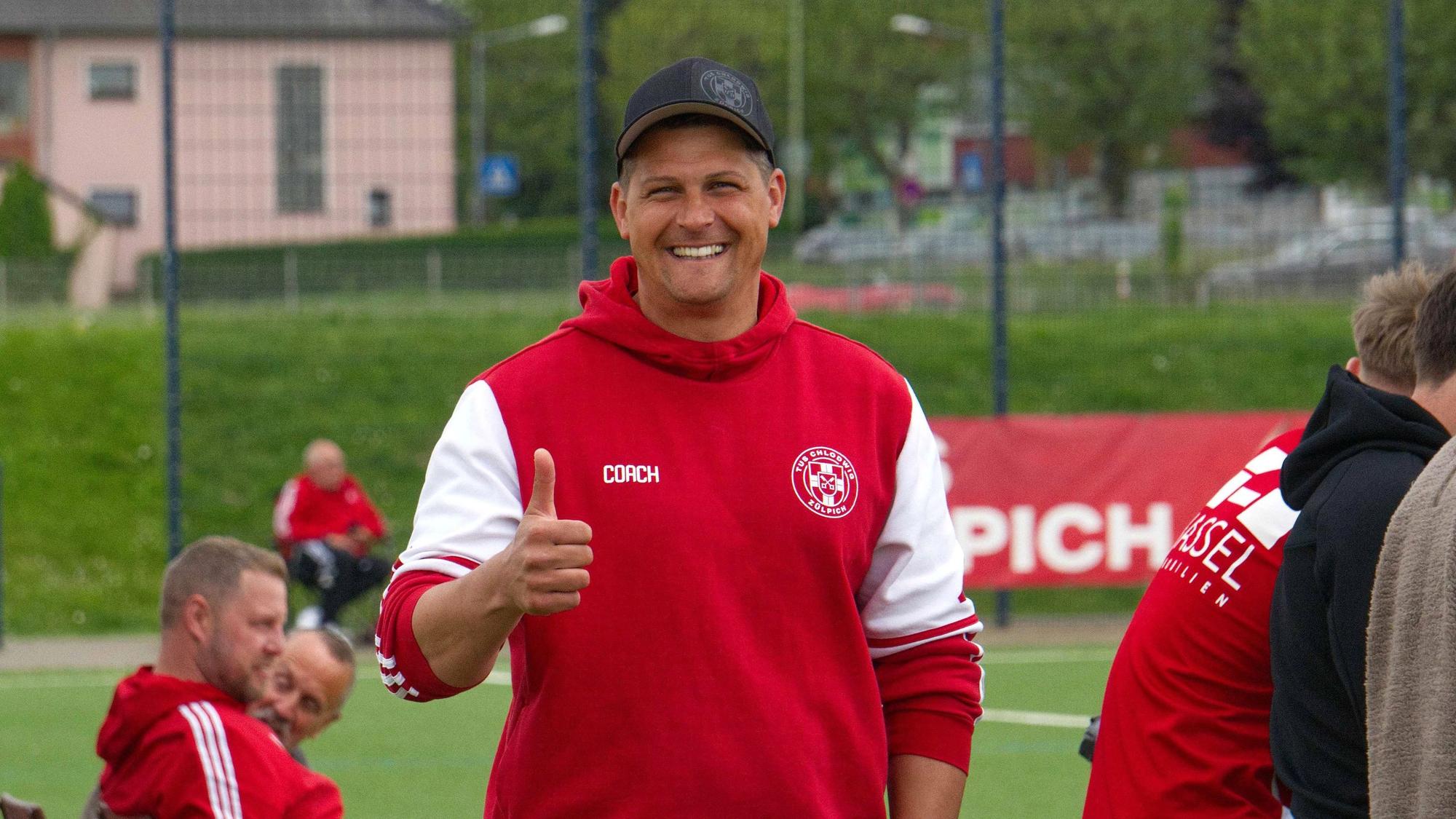 Das Bild zeigt den Trainer des TuS Zülpich, wie er in die Kamera lächelt.