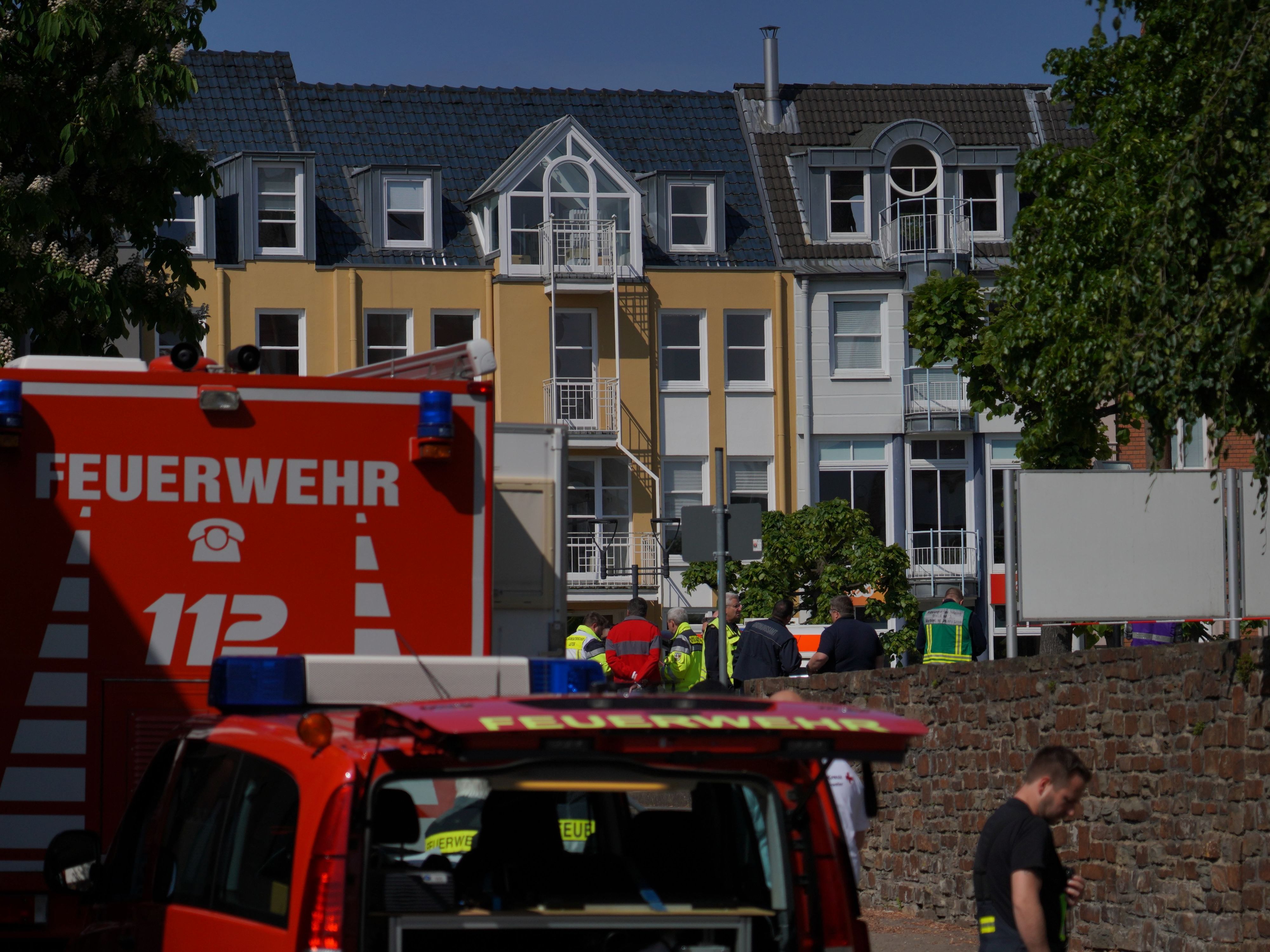 Rettungswagen, Polizisten und Polizeifahrzeuge stehen in der Nähe eines Einsatzortes. In einer Bankfiliale im rheinland-pfälzischen Sinzig ist es nach ersten Erkenntnissen der Polizei zu einer Geiselnahme gekommen.