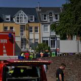 Rettungswagen, Polizisten und Polizeifahrzeuge stehen in der Nähe eines Einsatzortes. In einer Bankfiliale im rheinland-pfälzischen Sinzig ist es nach ersten Erkenntnissen der Polizei zu einer Geiselnahme gekommen.