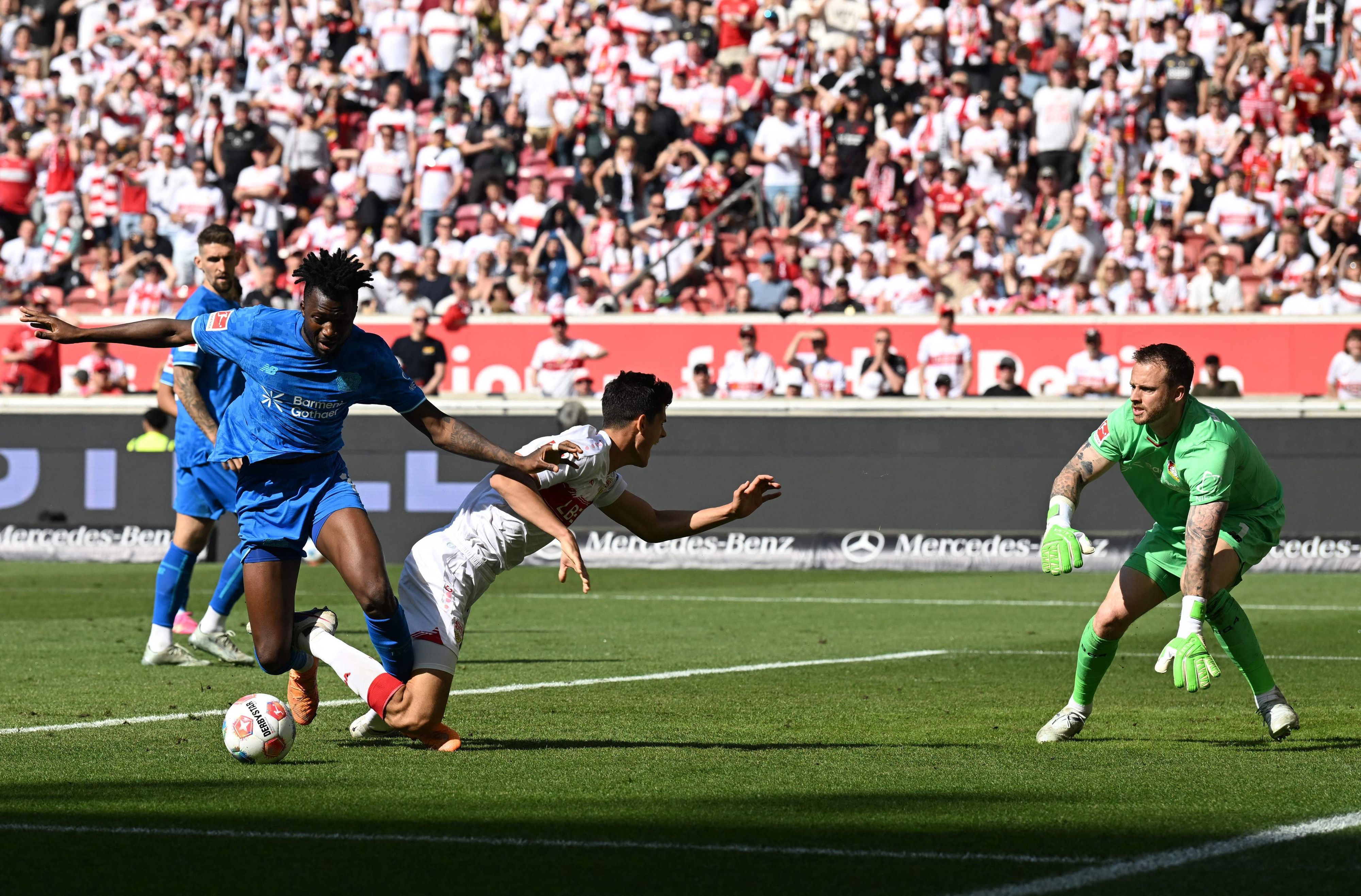 Bayer Leverkusen's Burkinabe defender #12 Edmond Tapsoba (L) and Stuttgart's Spanish midfielder #30 Chema Andres (C) vie for the ball in front of Bayer Leverkusen's Dutch goalkeeper #01 Mark Flekken (R) during the German first division Bundesliga football match between VfB Stuttgart and Bayer 04 Leverkusen in Stuttgart, southwestern Germany on May 9, 2026. (Photo by THOMAS KIENZLE / AFP) / DFL REGULATIONS PROHIBIT ANY USE OF PHOTOGRAPHS AS IMAGE SEQUENCES AND/OR QUASI-VIDEO