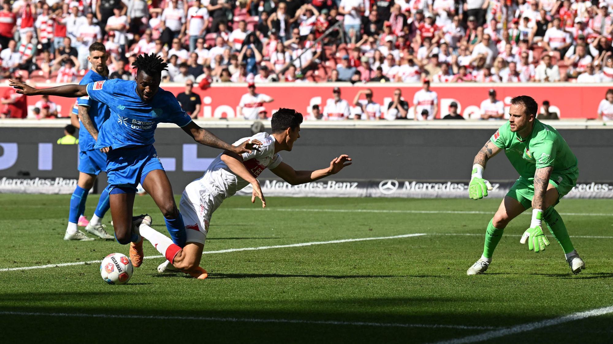 Bayer Leverkusen's Burkinabe defender #12 Edmond Tapsoba (L) and Stuttgart's Spanish midfielder #30 Chema Andres (C) vie for the ball in front of Bayer Leverkusen's Dutch goalkeeper #01 Mark Flekken (R) during the German first division Bundesliga football match between VfB Stuttgart and Bayer 04 Leverkusen in Stuttgart, southwestern Germany on May 9, 2026. (Photo by THOMAS KIENZLE / AFP) / DFL REGULATIONS PROHIBIT ANY USE OF PHOTOGRAPHS AS IMAGE SEQUENCES AND/OR QUASI-VIDEO