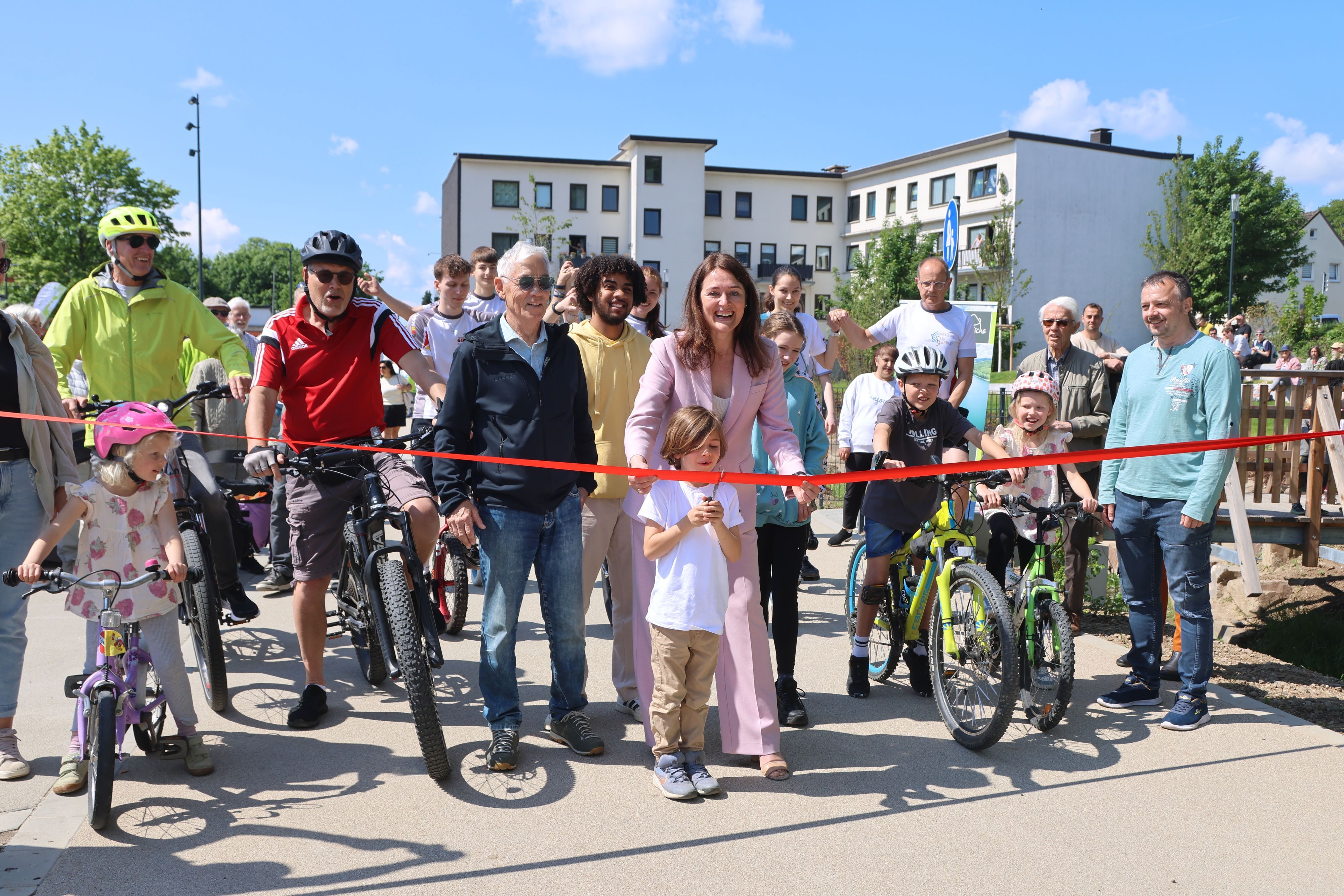 Larissa Weber und Vincent Gülmen zerschneiden das rote Band und geben den City-Radweg frei.