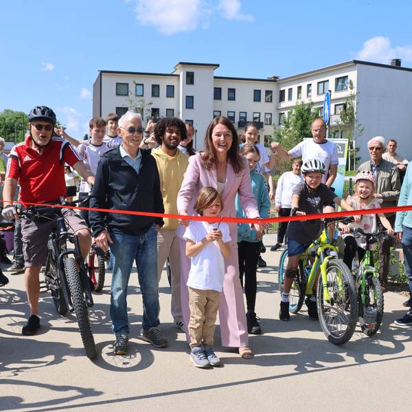 Larissa Weber und Vincent Gülmen zerschneiden das rote Band und geben den City-Radweg frei.