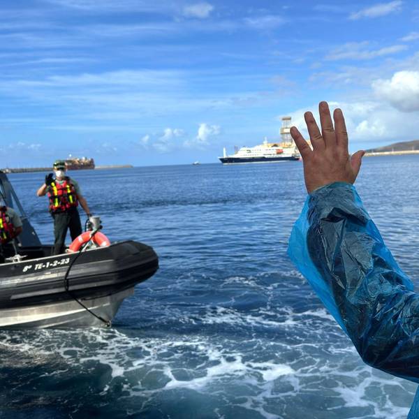 Teneriffa: Ein Person (r.) winkt Beamten der Guardia Civil zu, als sie am Sonntag (10. Mai) von dem vom Hantavirus befallenen Kreuzfahrtschiff MV Hondius im Hafen von Granadilla ausgeschifft wird.