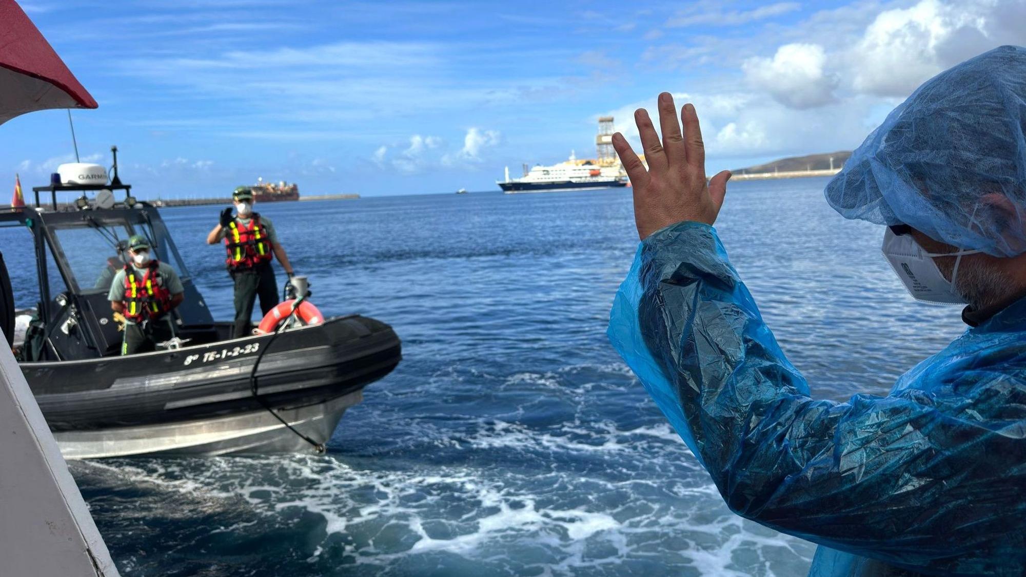 Teneriffa: Ein Person (r.) winkt Beamten der Guardia Civil zu, als sie am Sonntag (10. Mai) von dem vom Hantavirus befallenen Kreuzfahrtschiff MV Hondius im Hafen von Granadilla ausgeschifft wird.