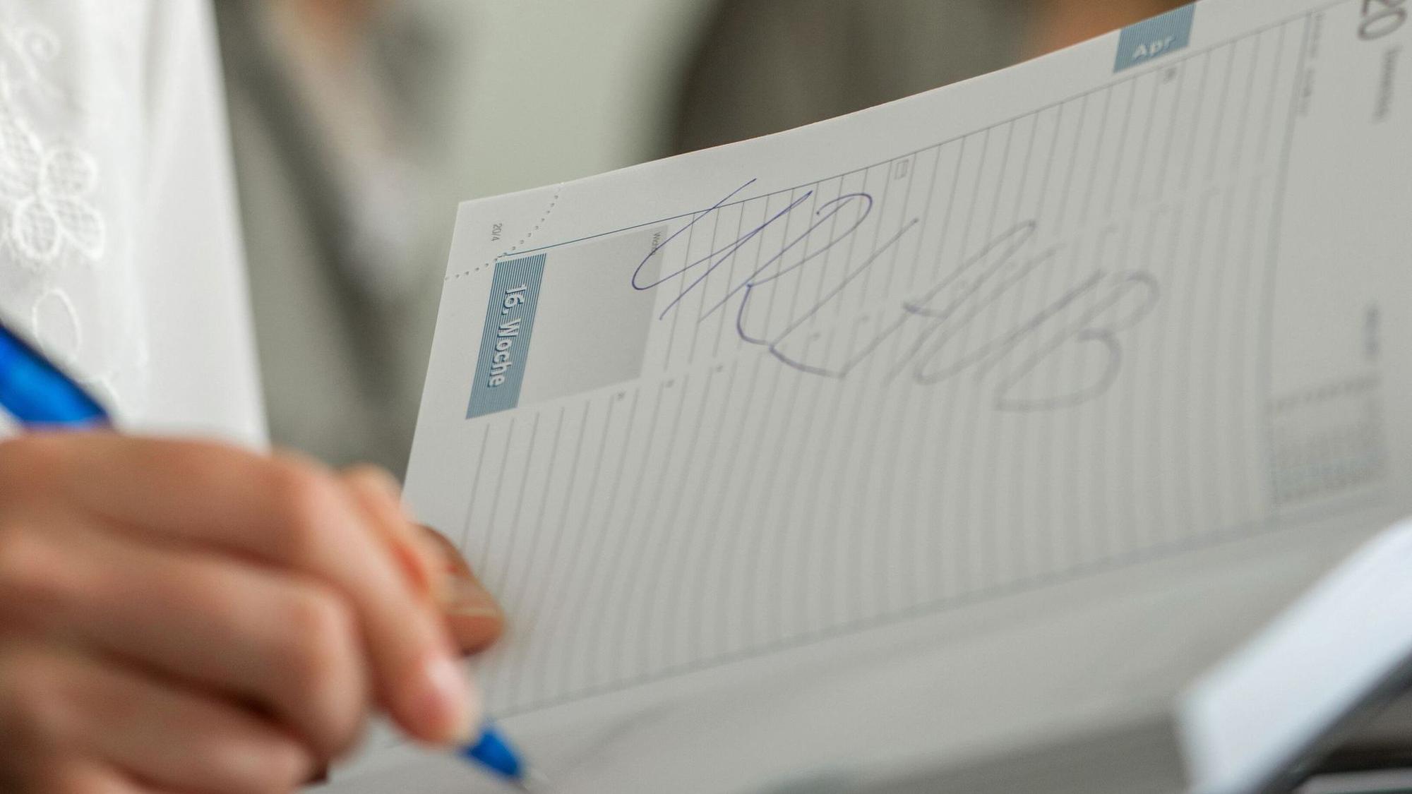 Frau trägt Urlaub in ihren Kalender ein