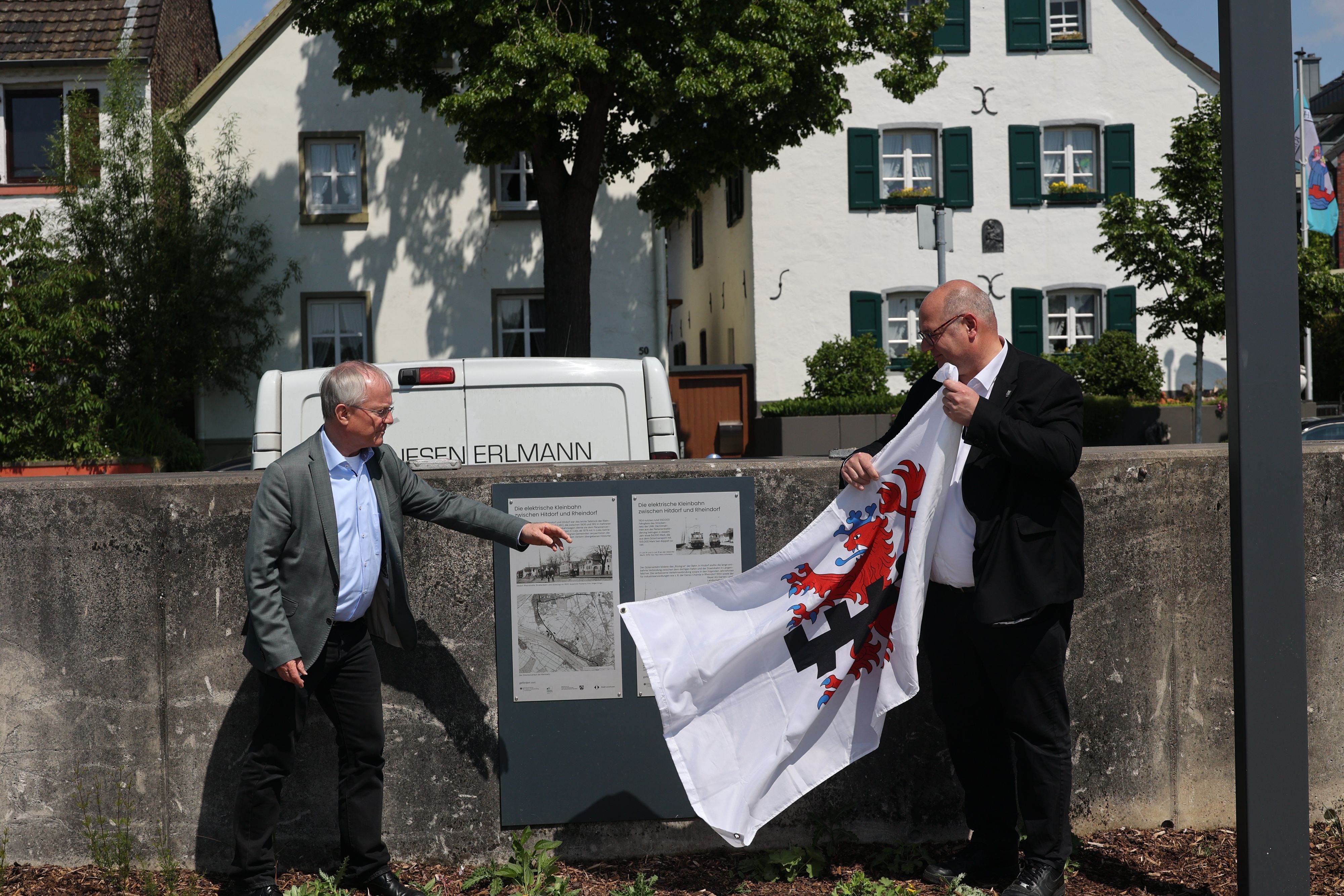 OB Stefan Hebbel und Rüdiger Scholz enthüllen die Infotafel über die ehemalige Bahnlinie in Hitdorf.