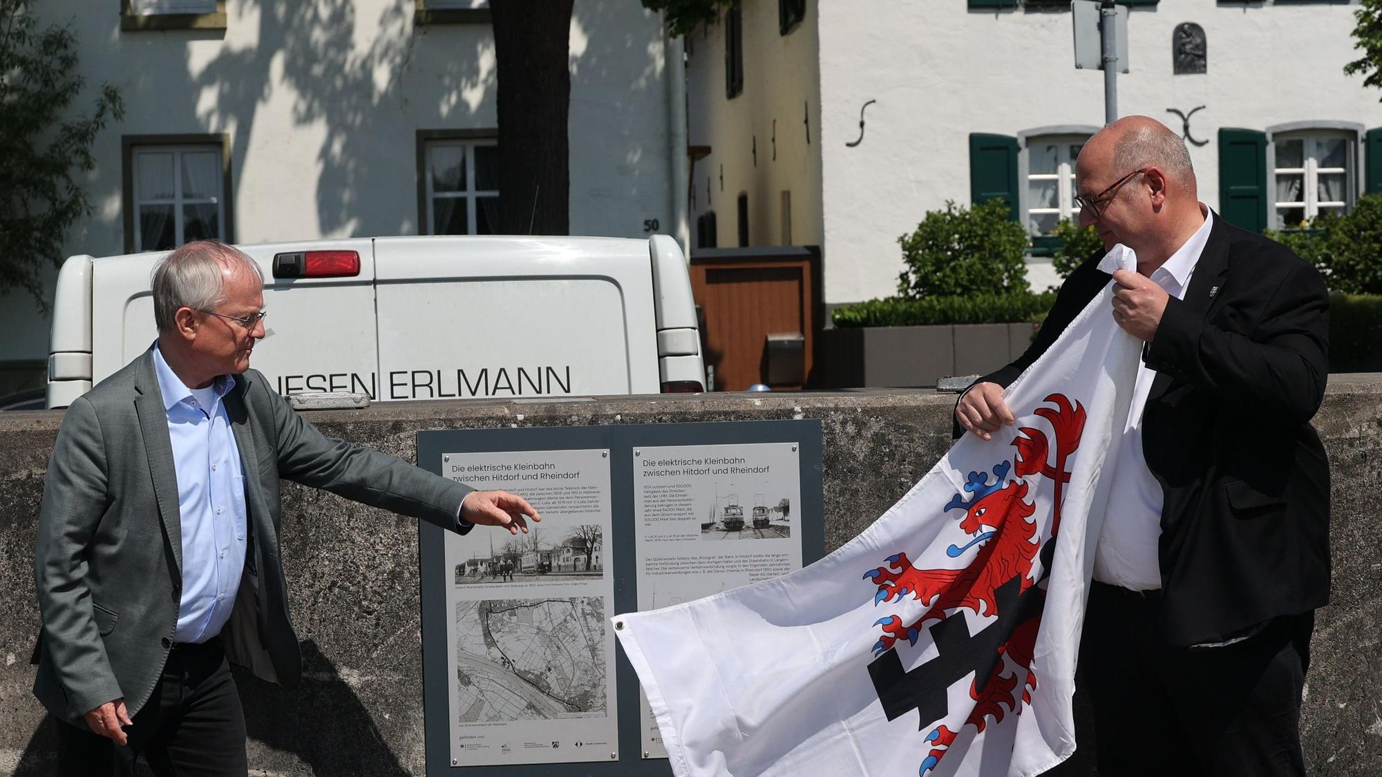 OB Stefan Hebbel und Rüdiger Scholz enthüllen die Infotafel über die ehemalige Bahnlinie in Hitdorf.
