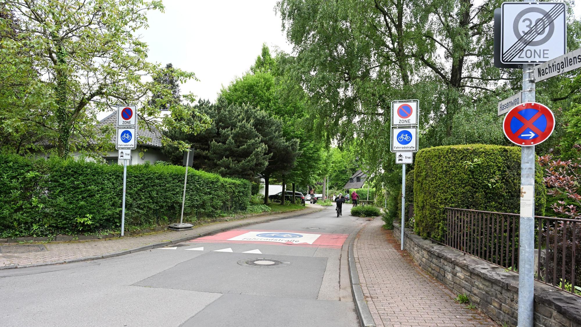 Rechts und links der Fahrbahn stehen Verkehrsschilder.