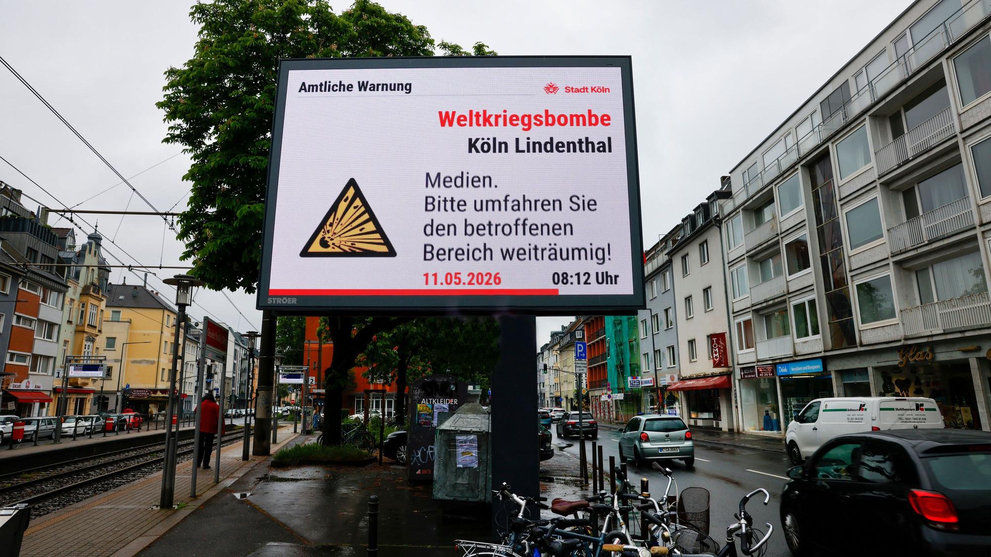 11.05.2026, Nordrhein-Westfalen, Köln: Auf einem Werbedisplay wird auf die Weltkriegsbombe in Lindenthal hingewiesen. Foto: Thomas Banneyer/dpa +++ dpa-Bildfunk +++