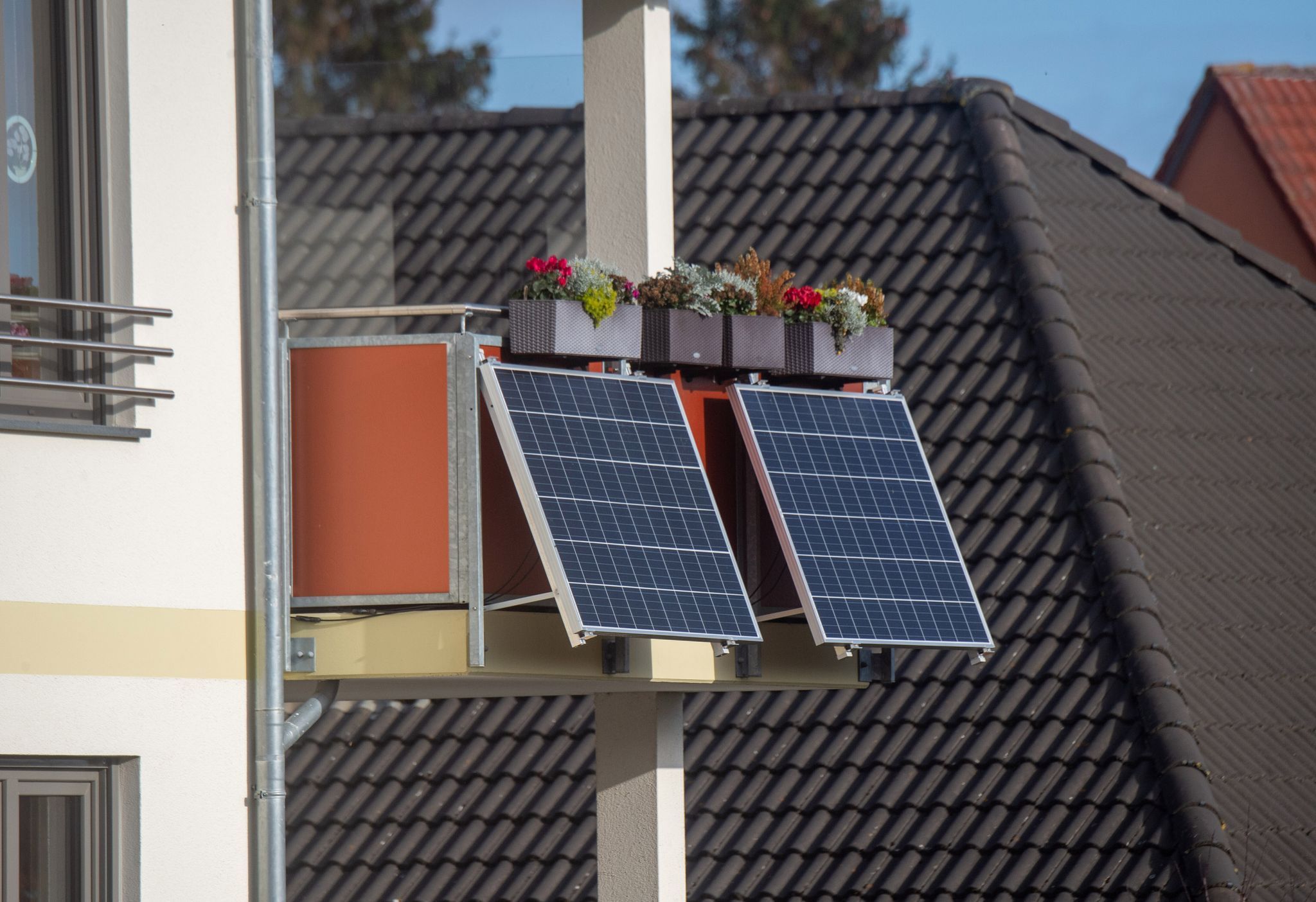 Solarmodule für ein Balkonkraftwerk hängen an einem Balkon