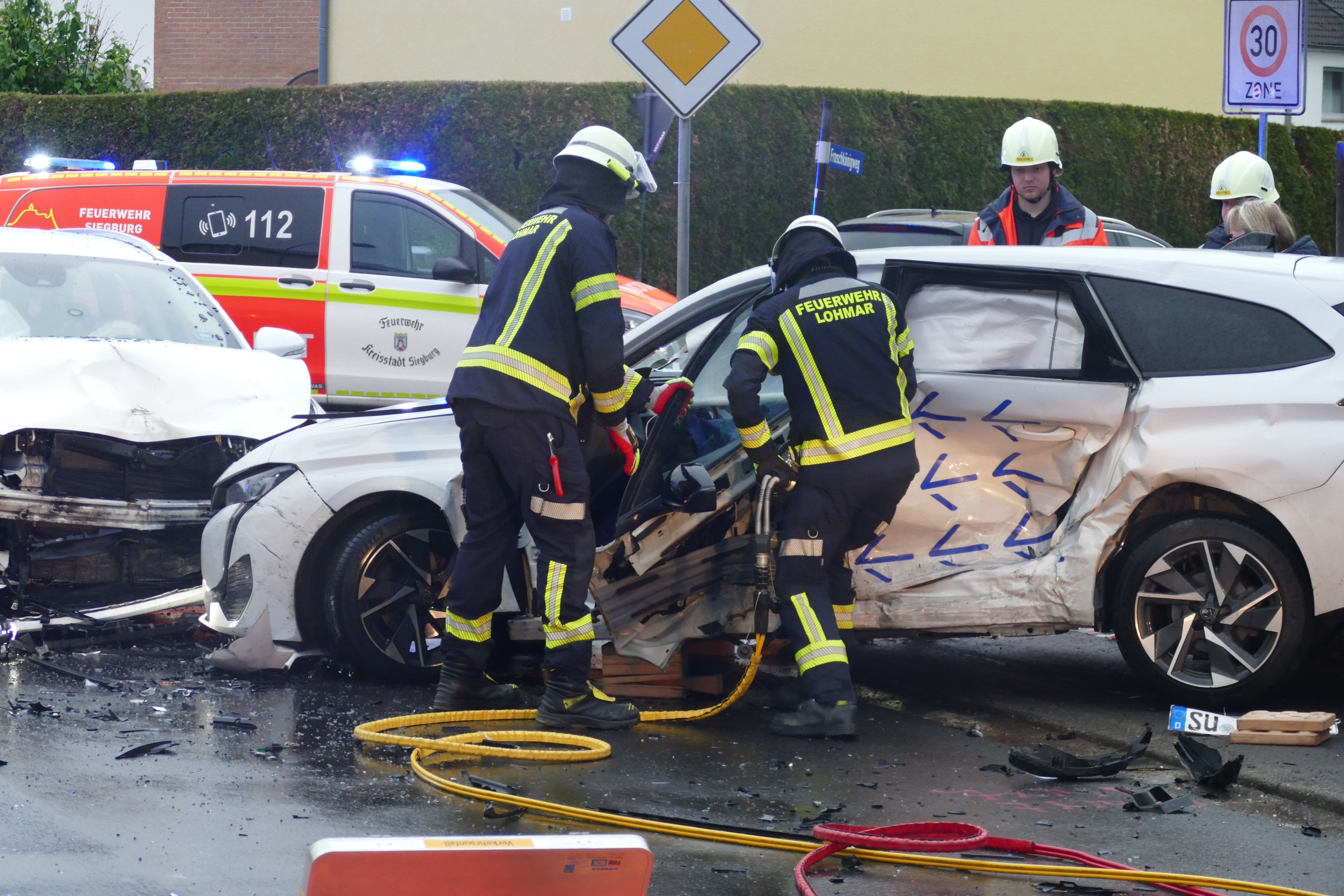 Feuerwehrleute arbeiten an einem Autowrack.