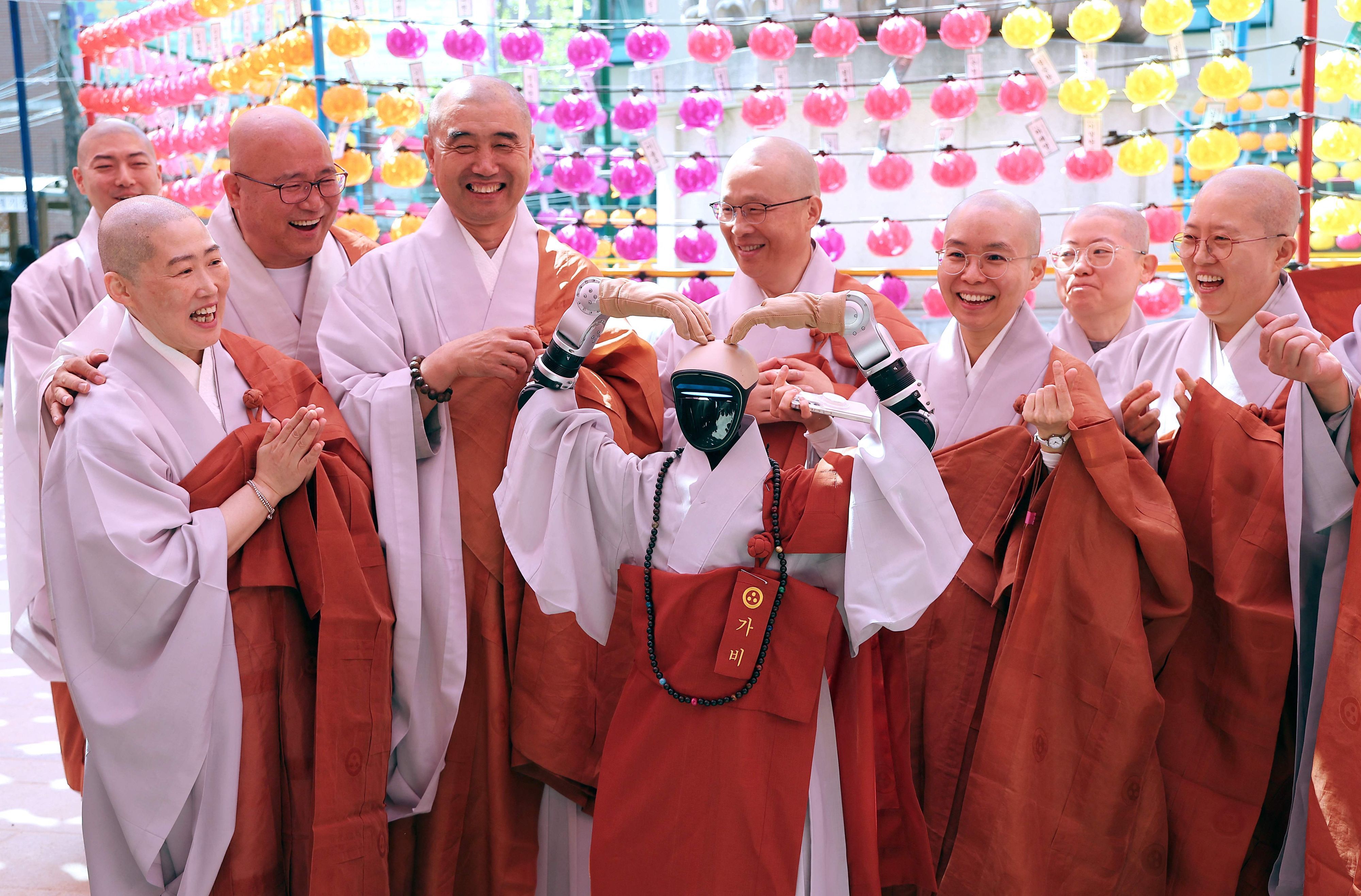 Gabi (C), a humanoid robot dressed as a Buddhist monk, poses with Buddhist monks as it attends an ordination ceremony as part of celebrations for the upcoming Buddha's birthday at Jogye Temple in Seoul on May 6, 2026.