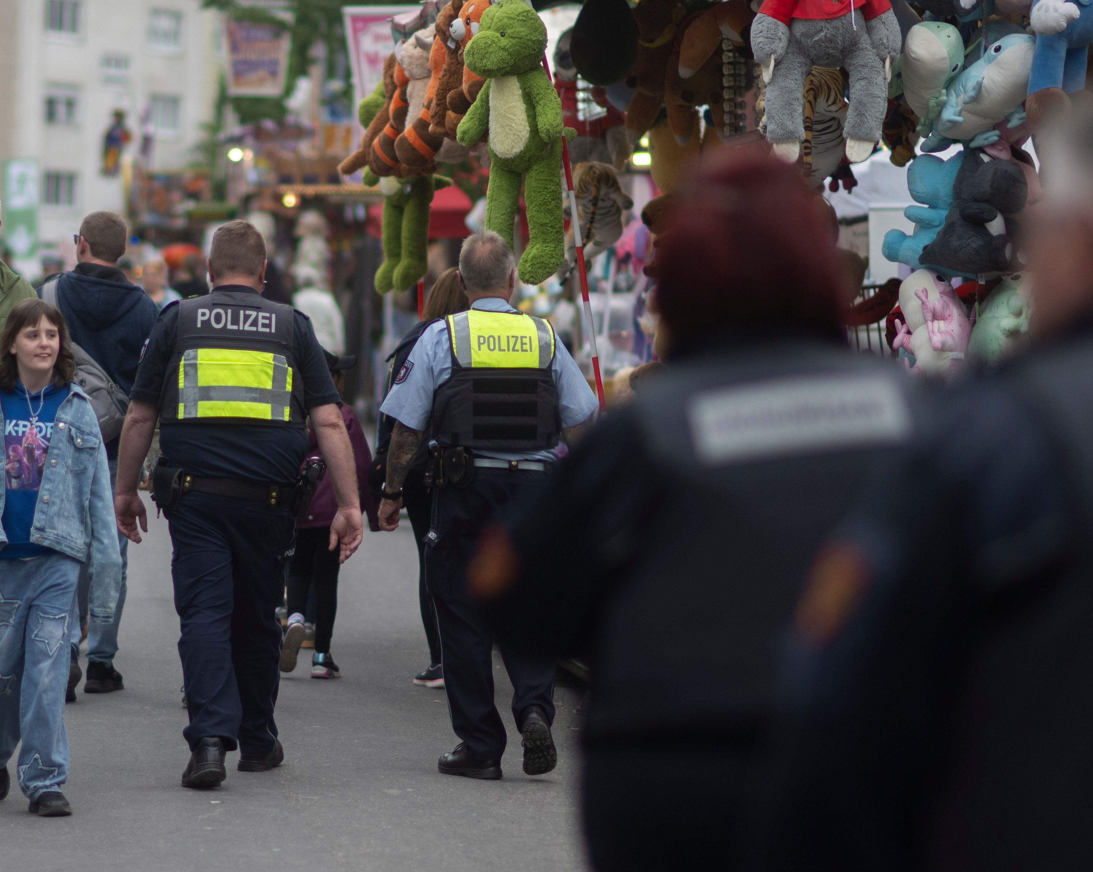 Das Bild zeigt Mitarbeitende des Ordnungsamts und der Polizei, während sie auf der Kirmes Streife gehen.